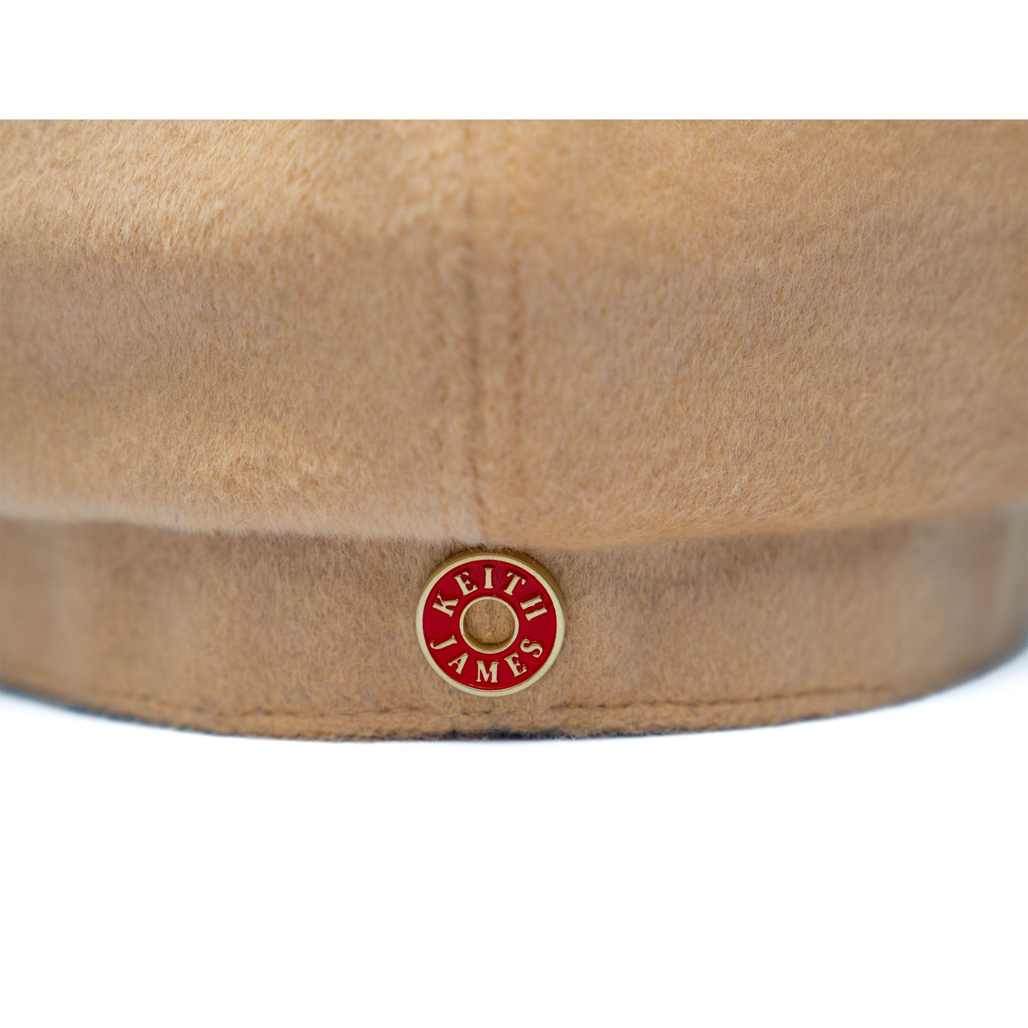 A beige colored wool hat with a cotton twill visor, featuring a satin padded sweatband and a signature logo pin.
