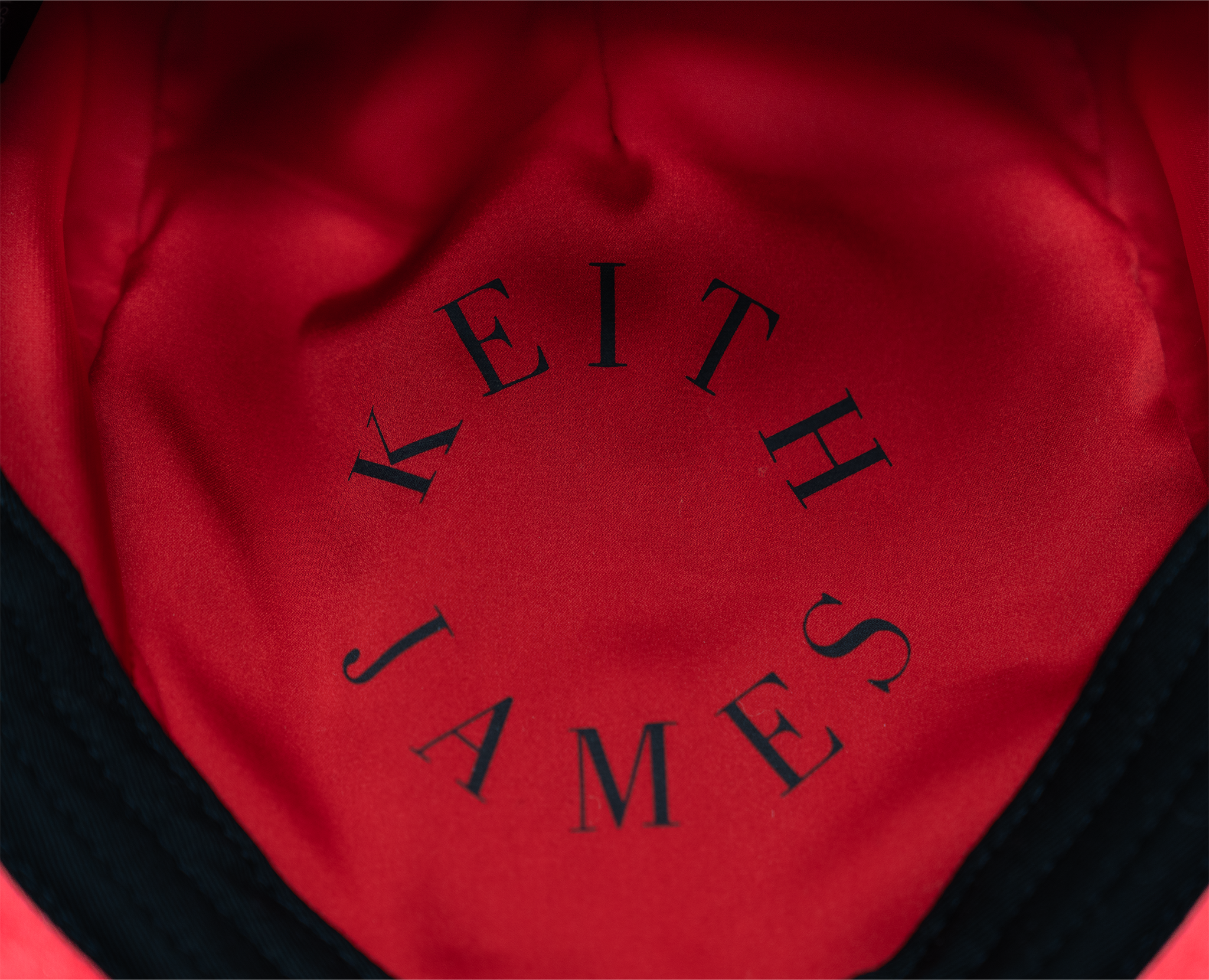 A black color cap with a visor, made of wool with satin lining and a logo pin on the front.
