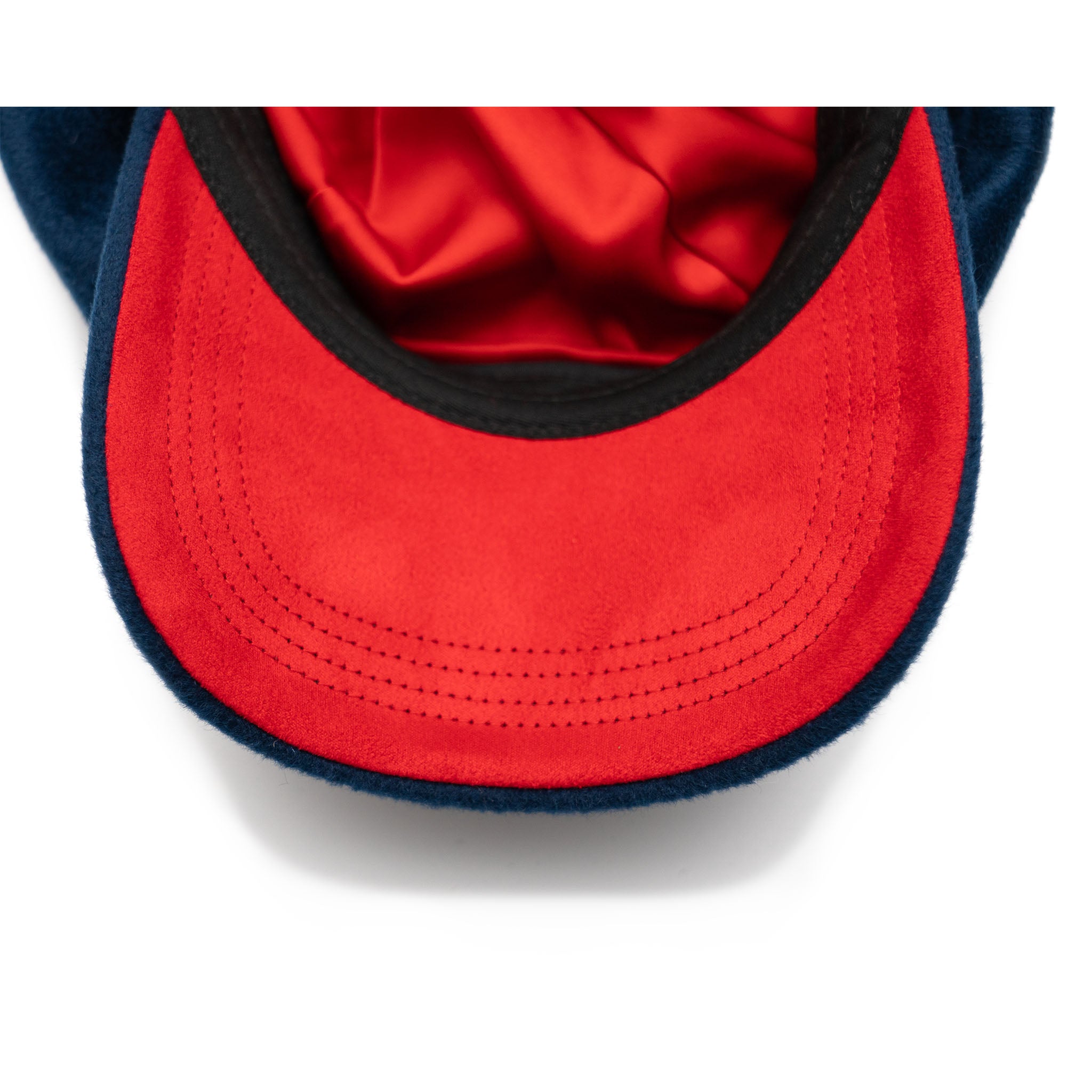 A sapphire blue colored hat made of wool with a satin lining and gold hardware.