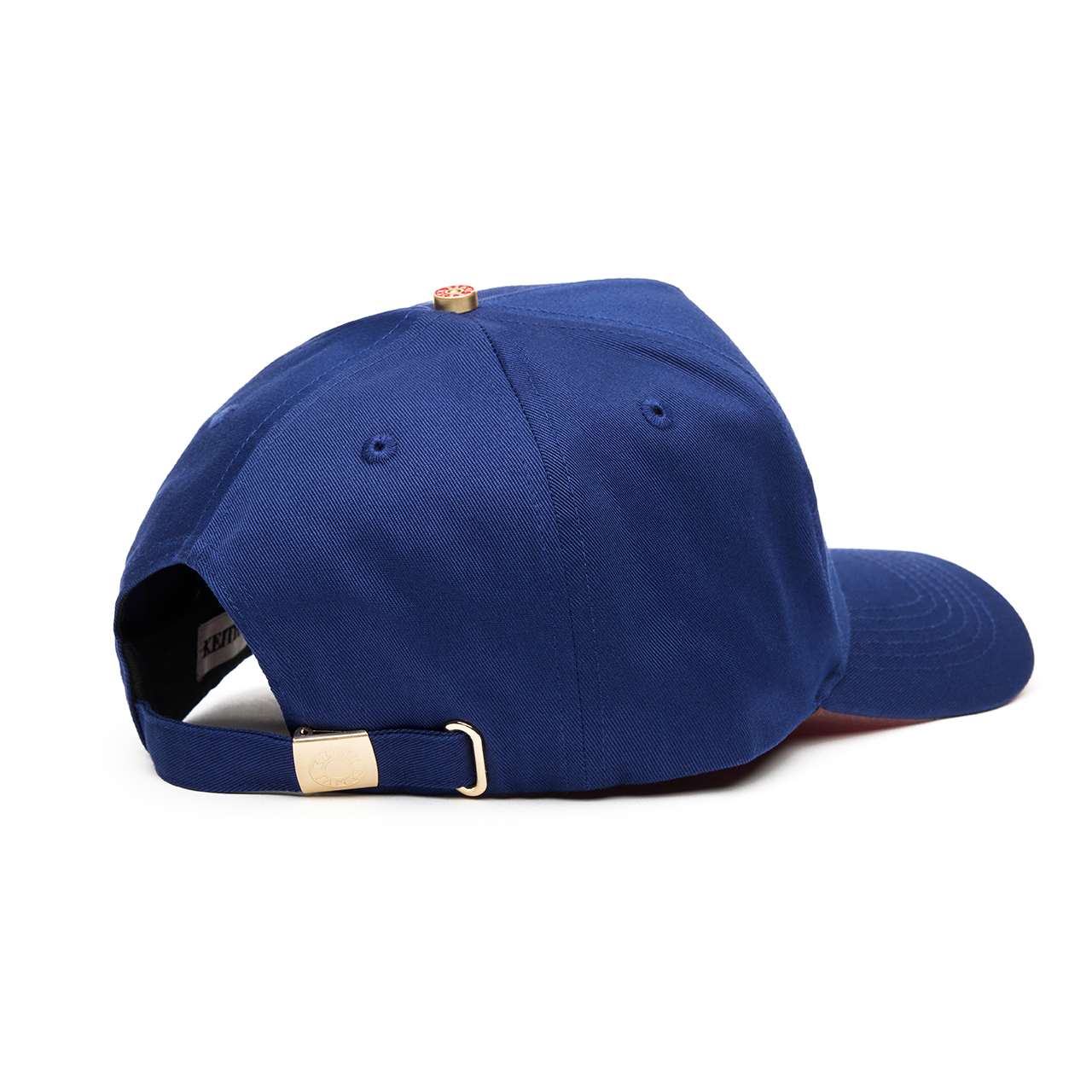 A navy blue 5 panel baseball cap with an adjustable band and a logo embroidered on the front with a red bottom brim.