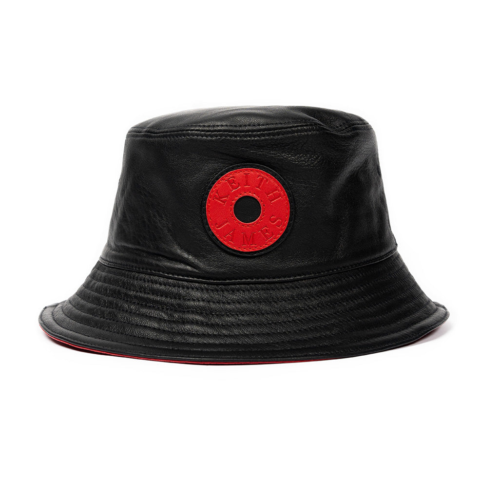 A jet black leather bucket hat with a red stamped leather logo circle in the center.