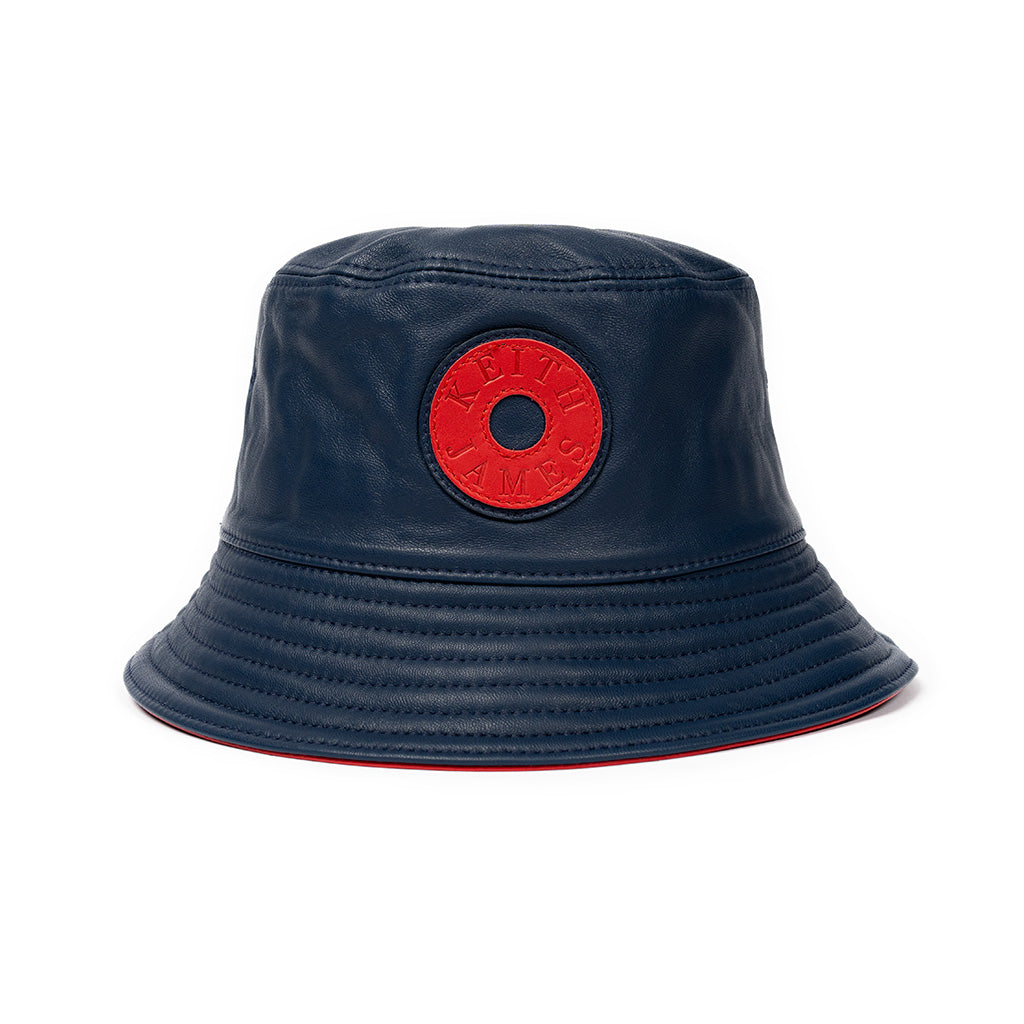A navy blue leather bucket hat with a stamped leather logo circle on the front.
