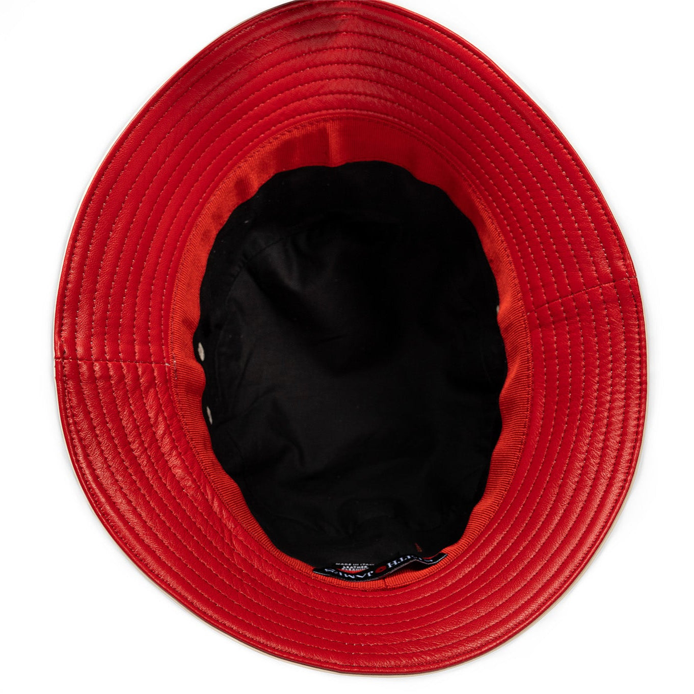 A leather bucket hat with a red stamped leather logo circle in the center.
