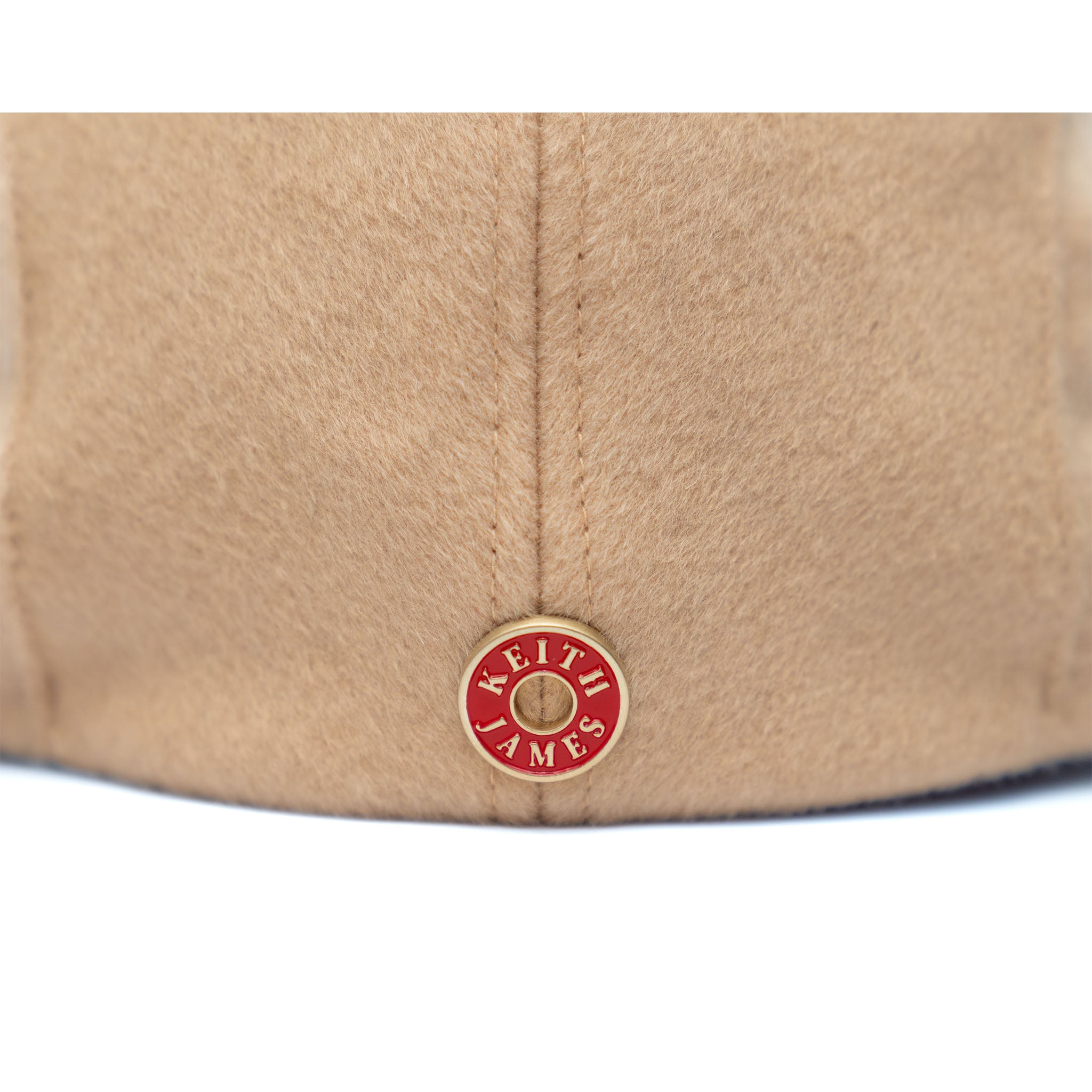 A beige Newsboy cap made of Australian wool with a cotton twill visor, featuring a satin padded sweatband and a signature logo pin.
