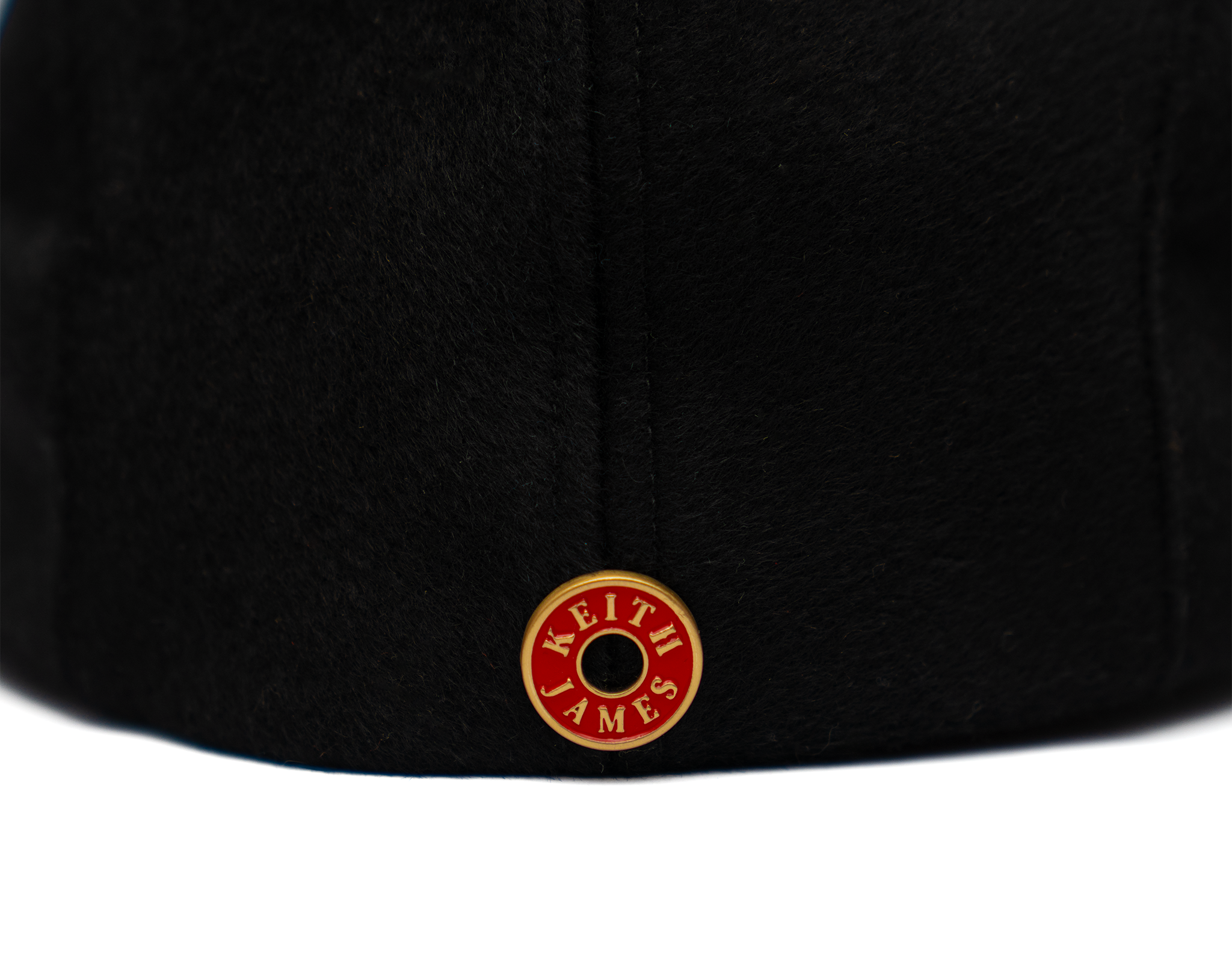 A black flat cap made of wool with a satin lining and gold hardware.