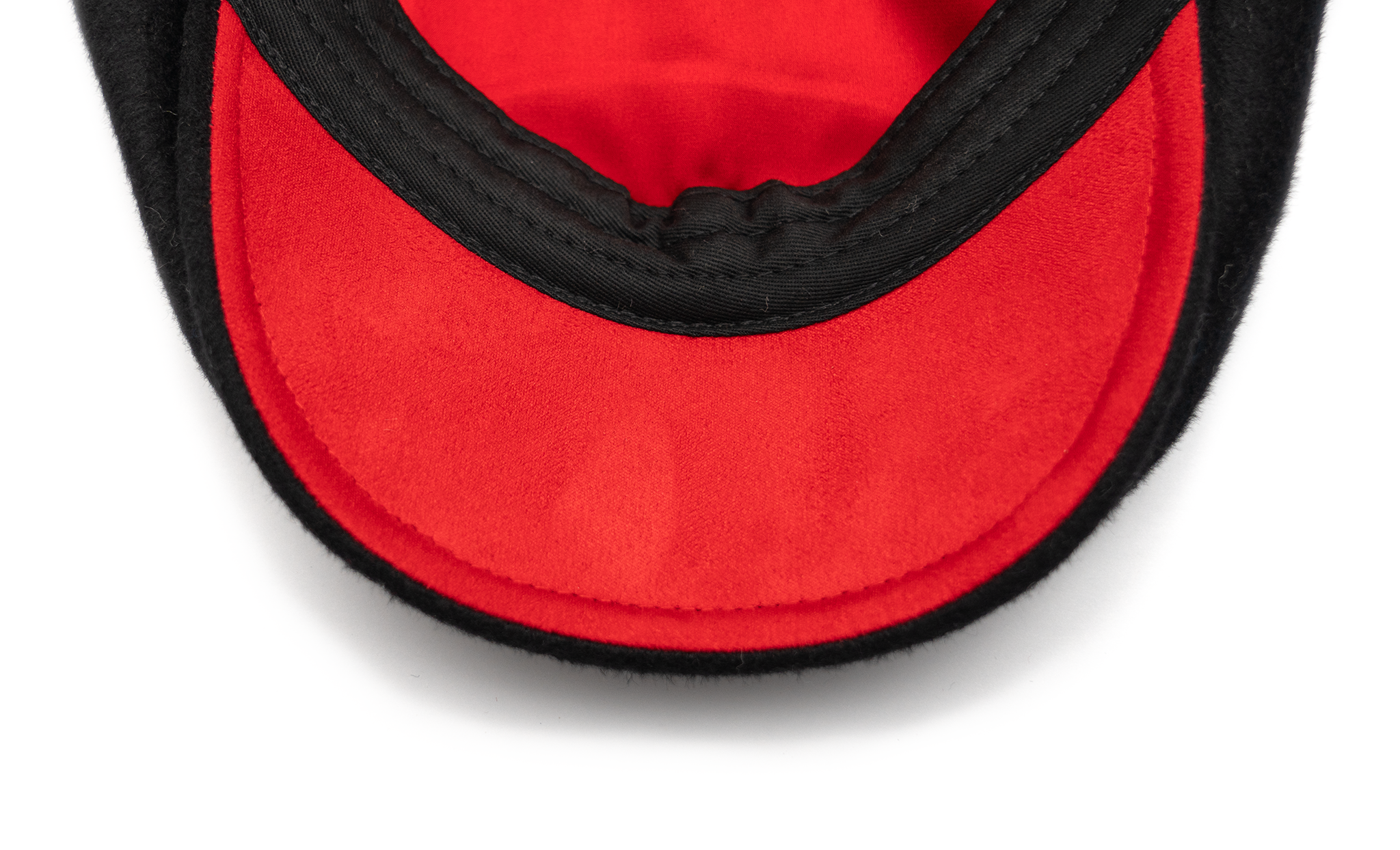 A black flat cap made of wool with a satin lining and gold hardware.