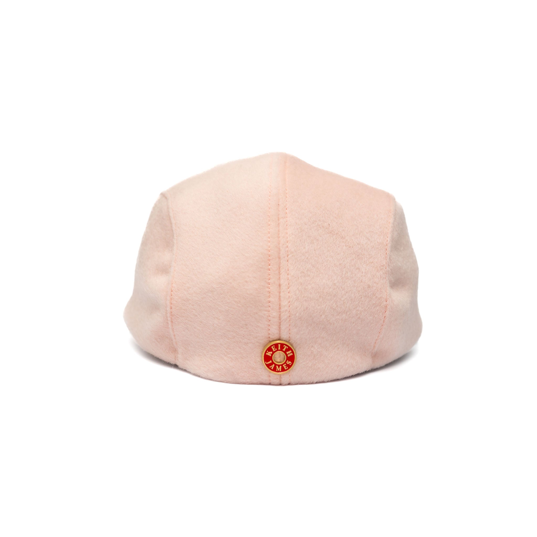 A soft pink newsboy cap with a flat visor, made of Australian wool, featuring a satin lining and gold hardware.