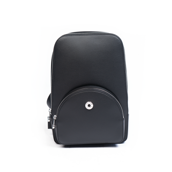 A jet black, leather backpack with a front pocket and a central zipper closure. The backpack features a compact design suitable for personal use.