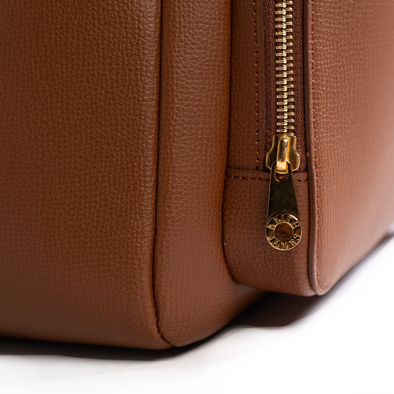 A cocoa brown backpack with a front zipper pocket and side mesh pockets, made of leather.