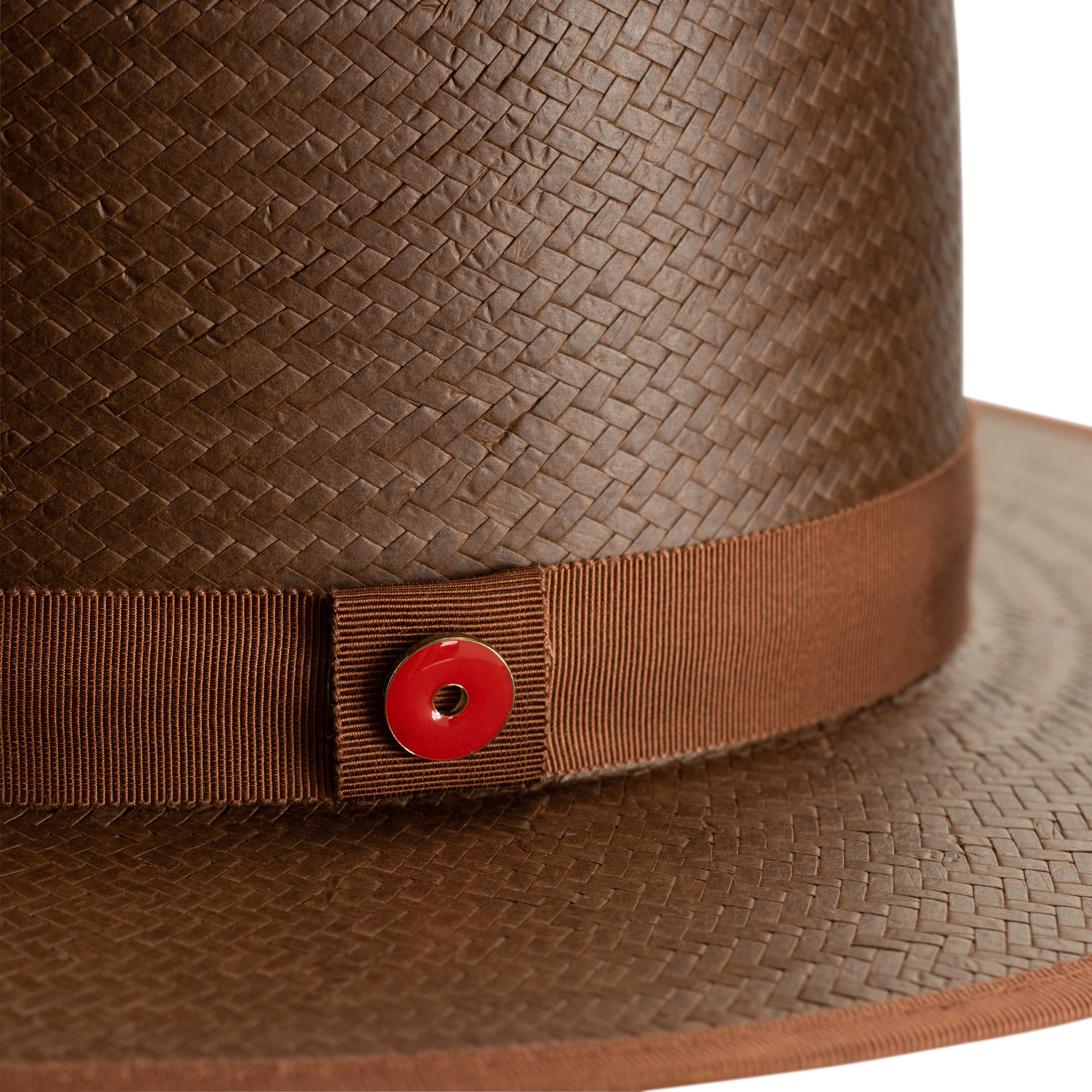 Brown straw hat with a leather band and red button on a white background