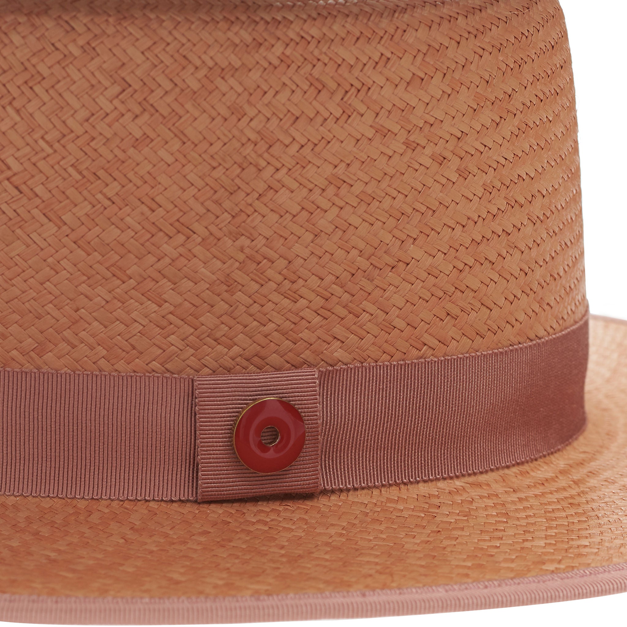 Pink straw hat with a band and button on a white background