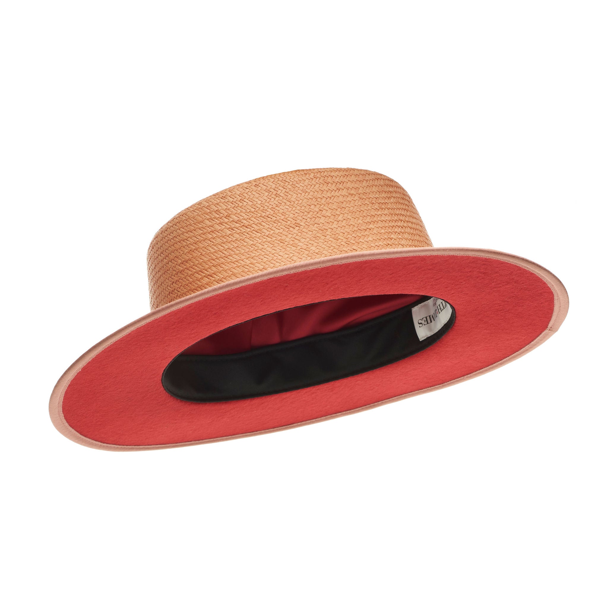 Pink straw hat with a band and button on a white background