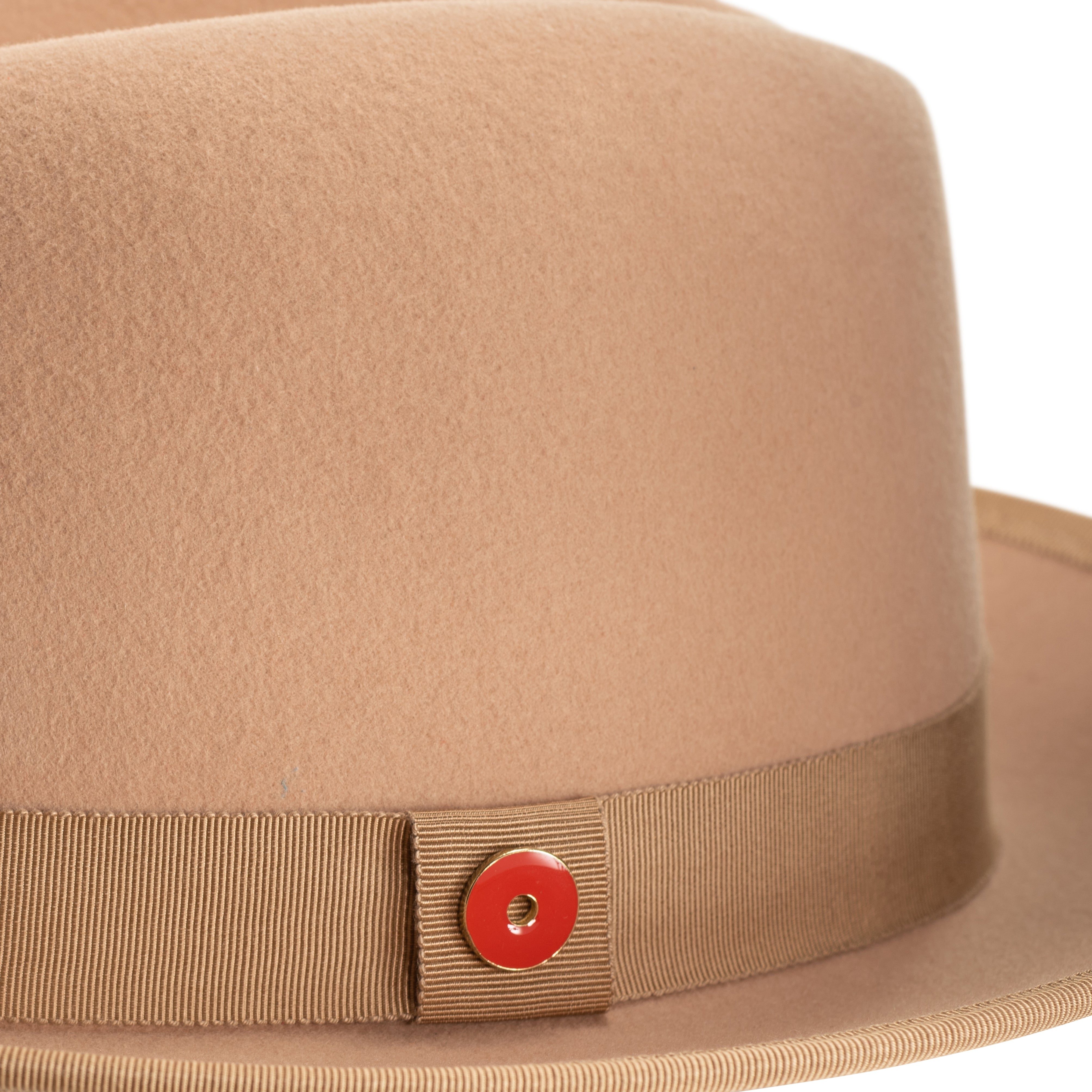 A golden honey colored fedora with a red ribbon trim and a red bottom brim, featuring a signature logo pin.