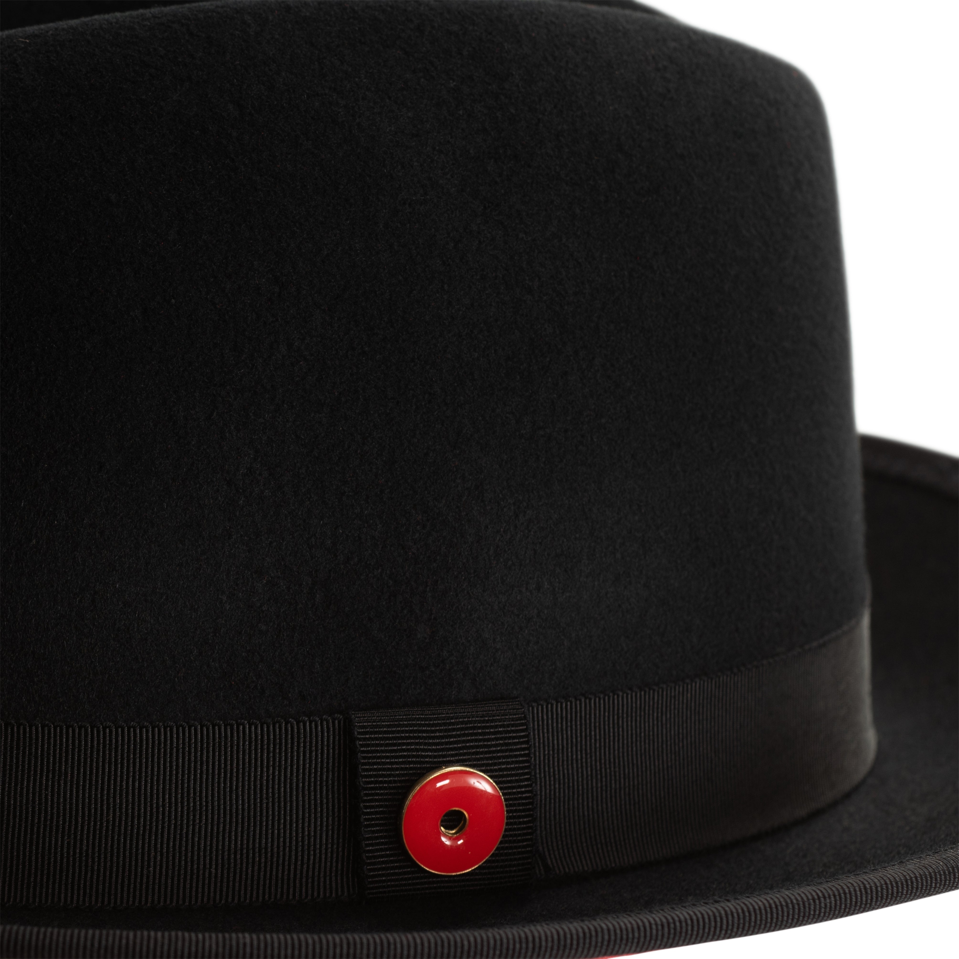 A classic black fedora hat with a red band and a signature logo pin.