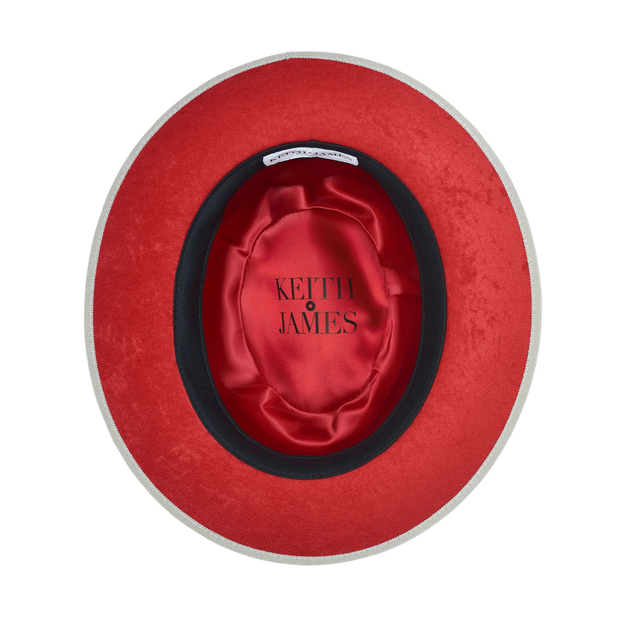 A sandy beige fedora with a red bottom brim and a signature logo pin.