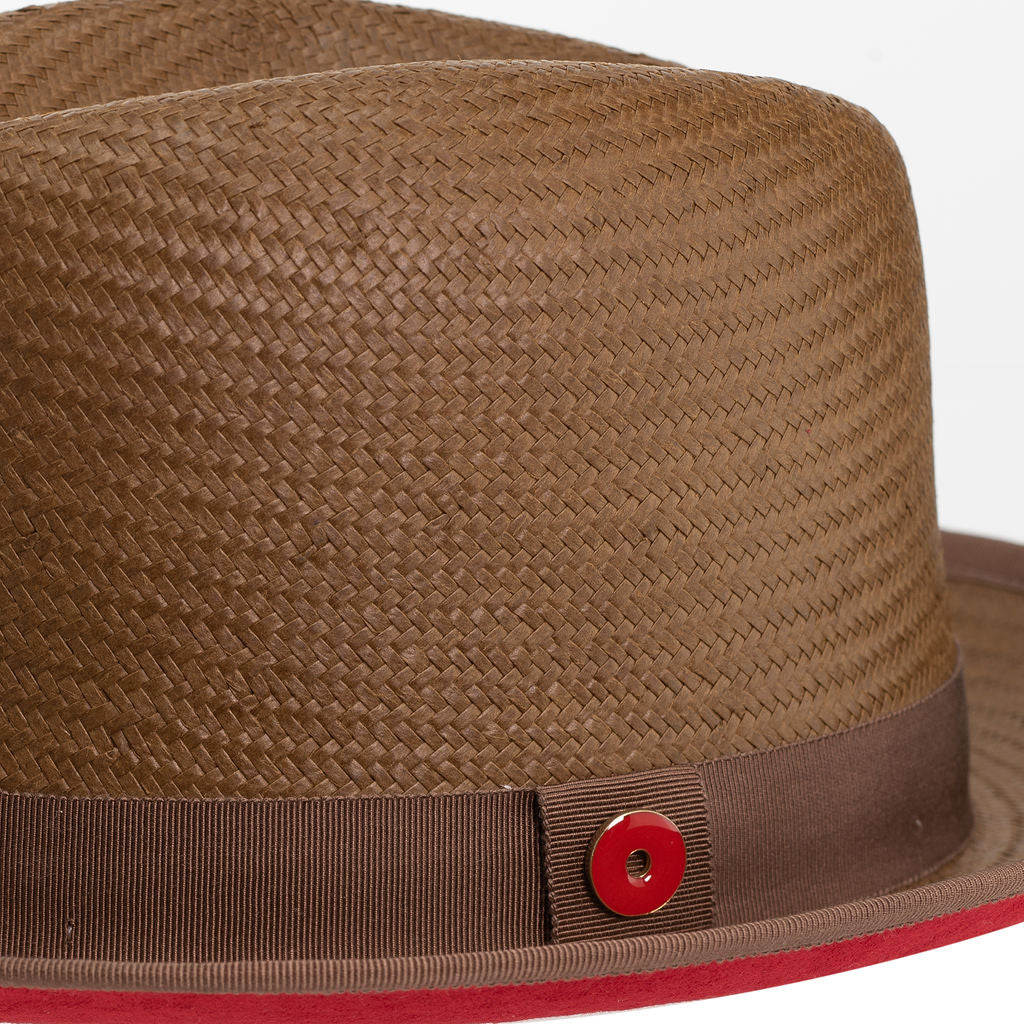 A cocoa brown classic center-creased fedora with a 2.5 inch curved brim, ribbon trim, and a red bottom brim.