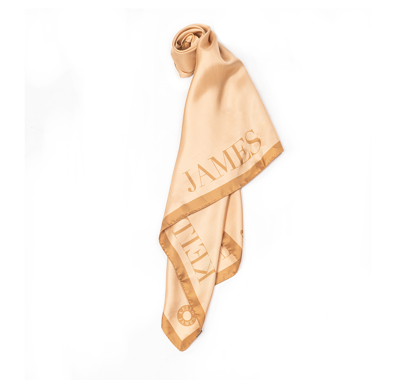 A rolled-up silk scarf with cream and tan colors, featuring text that appears to be a name and the brand 'Keith James'.