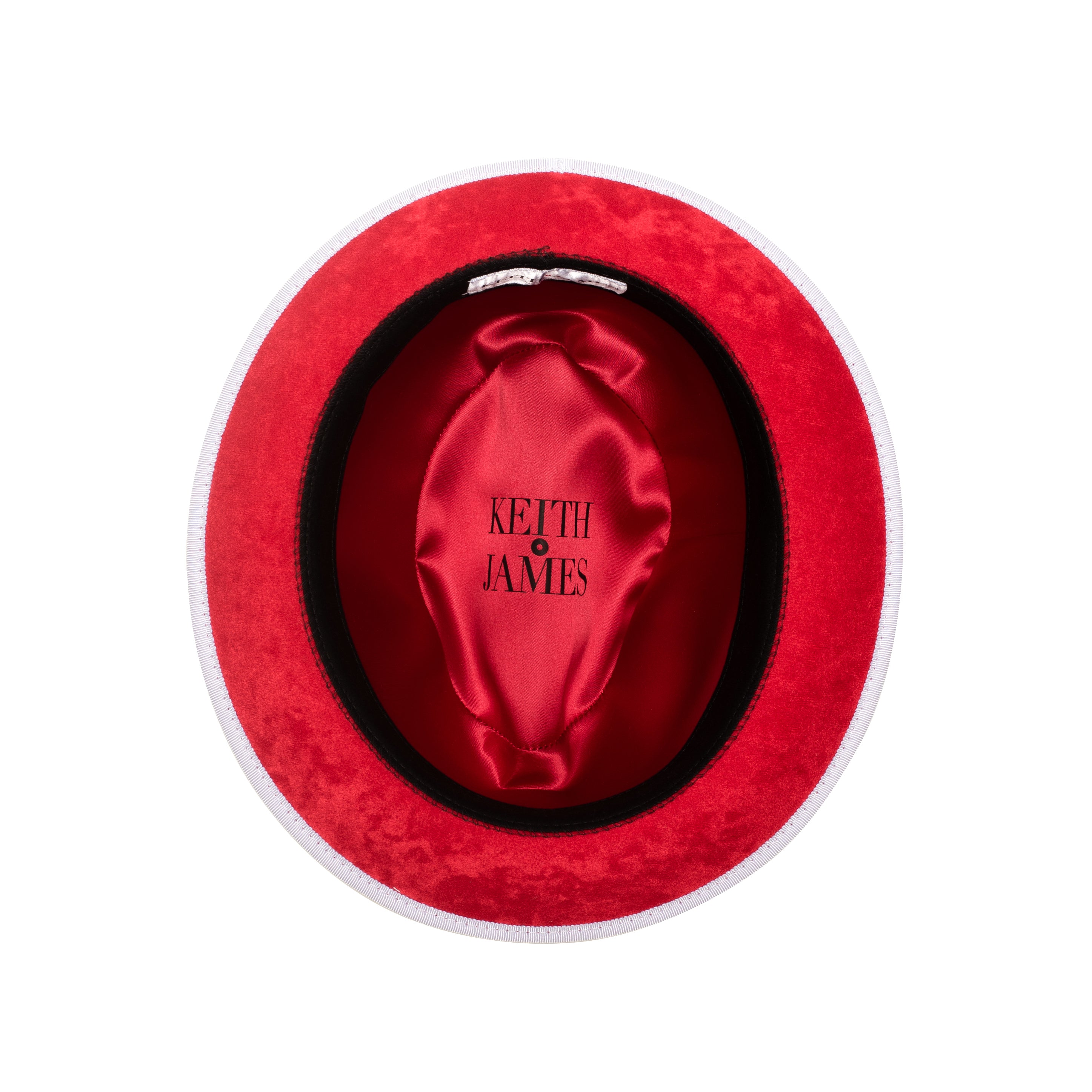 A snow white colored fedora hat with a white and red ribbon around the base and a red bottom brim, featuring a signature logo pin.