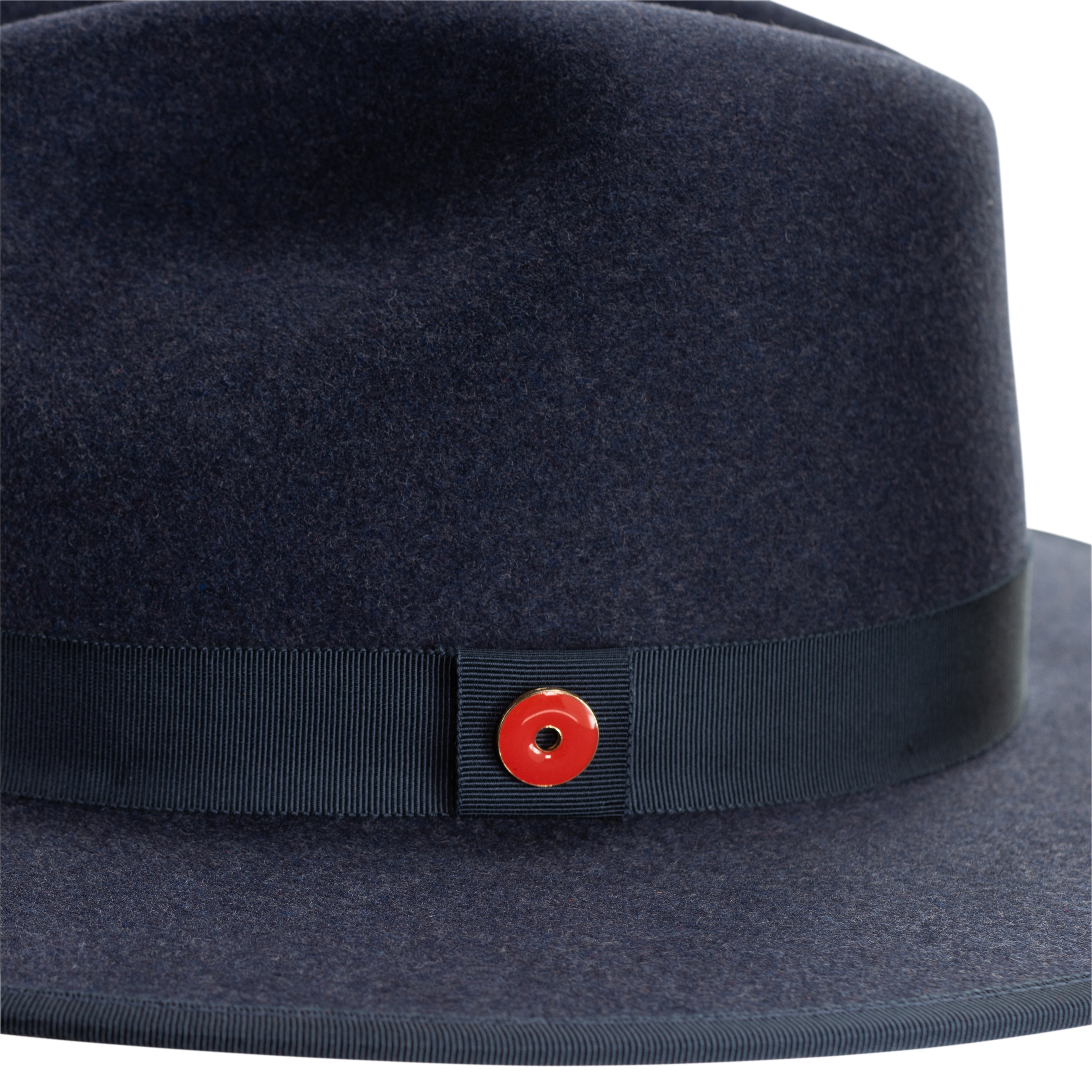A denim blue fedora hat with a pinched crown, flat brim, and bound edge. It includes a classic ribbon trim, a signature logo pin, and a red bottom brim.