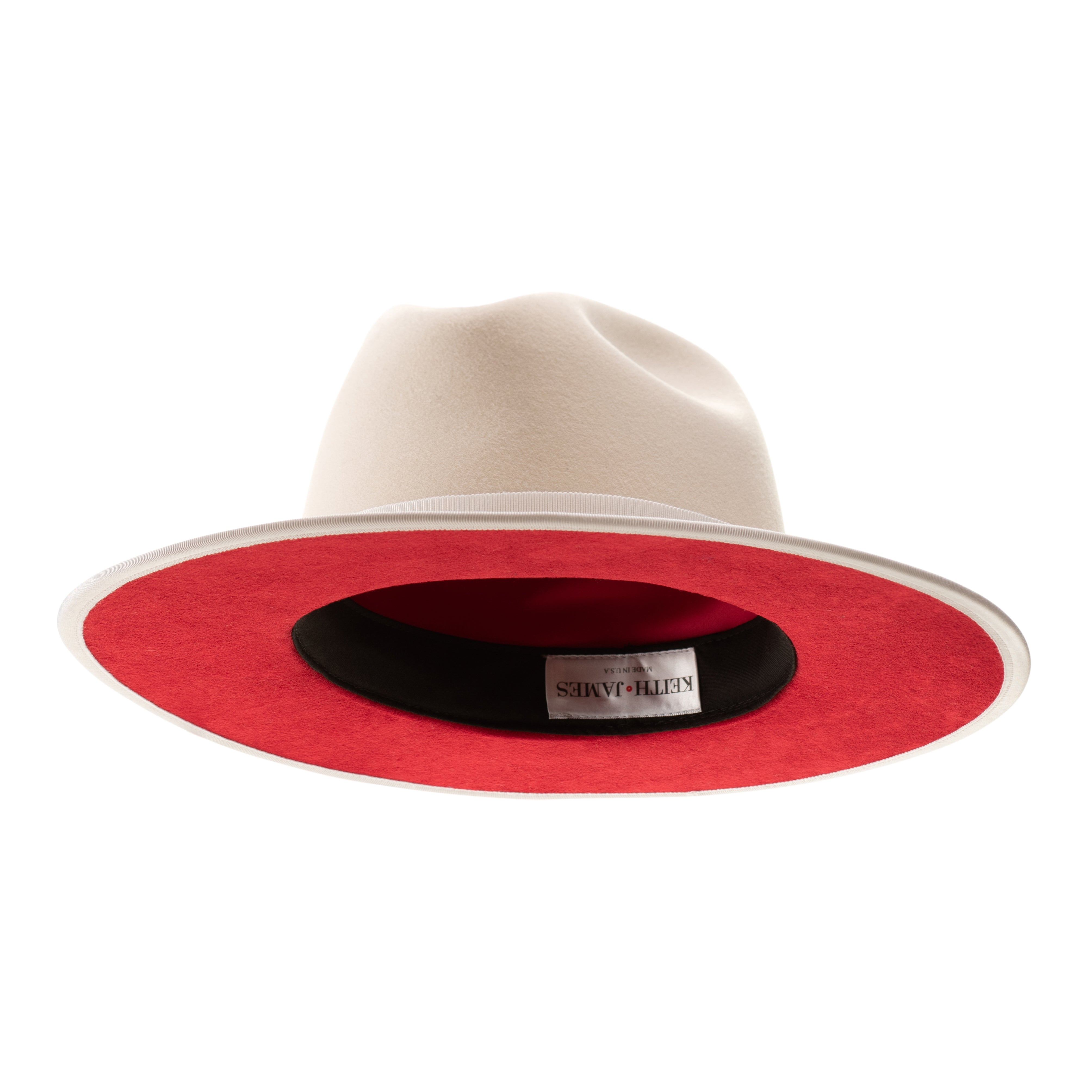 A snow white fedora hat with a pinched crown, flat brim, and bound edge. It includes a classic ribbon trim, a signature logo pin, and a red bottom brim.