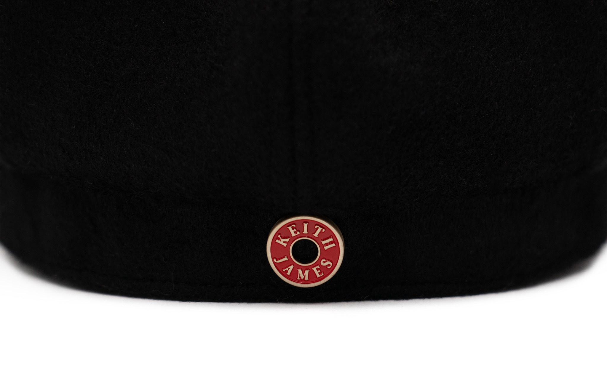 A black color cap with a visor, made of wool with satin lining and a logo pin on the front.