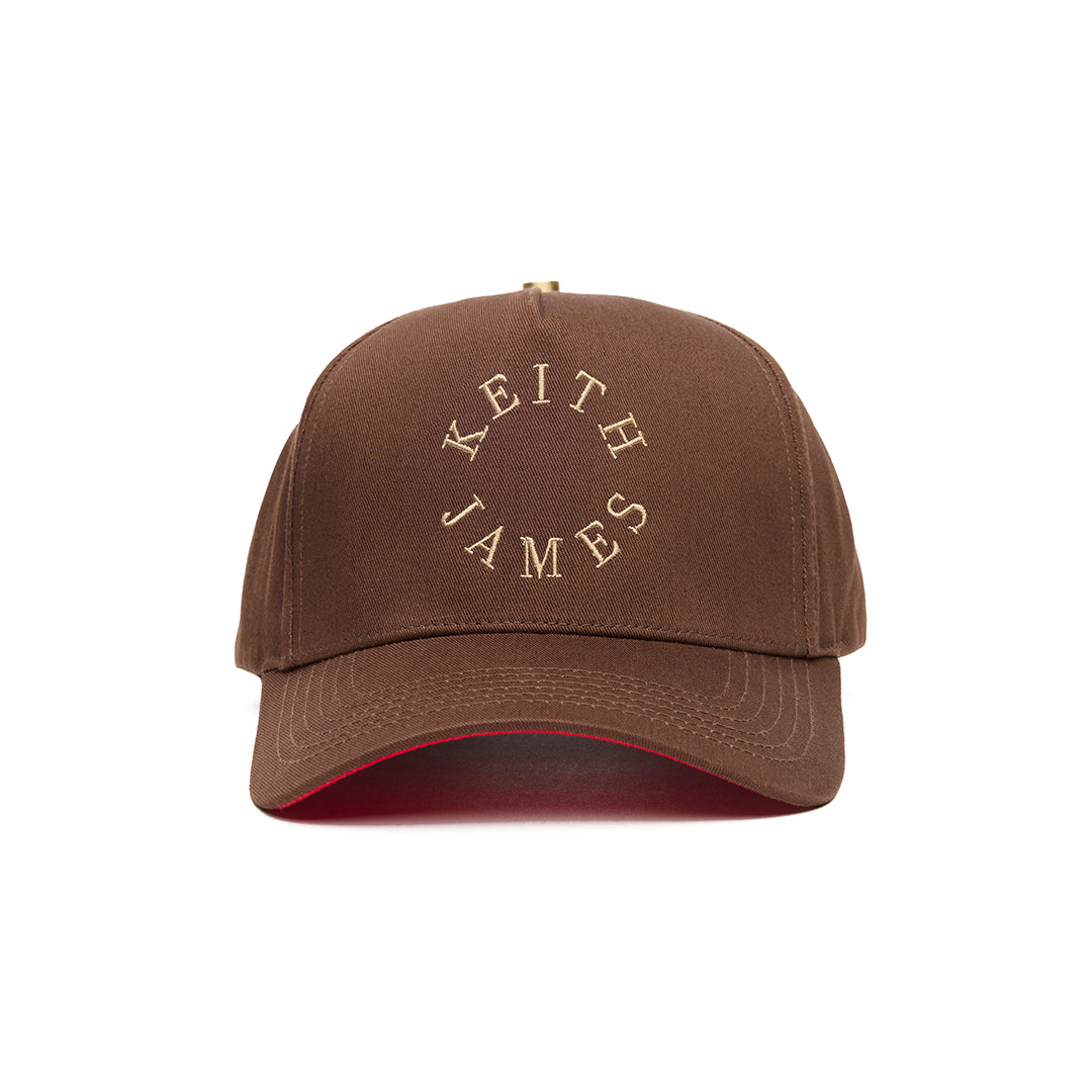 A brown 5 panel baseball cap with 'KEITH JAMES' embroidered in a circular logo on the front.