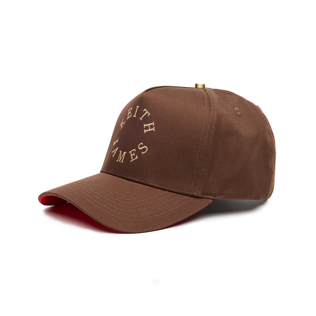 A brown 5 panel baseball cap with 'KEITH JAMES' embroidered in a circular logo on the front.