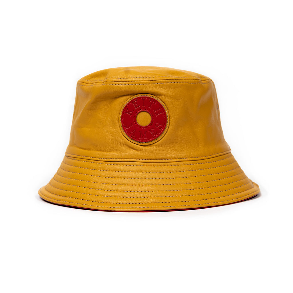 A canary yellow leather bucket hat with a stamped leather logo circle in the center.