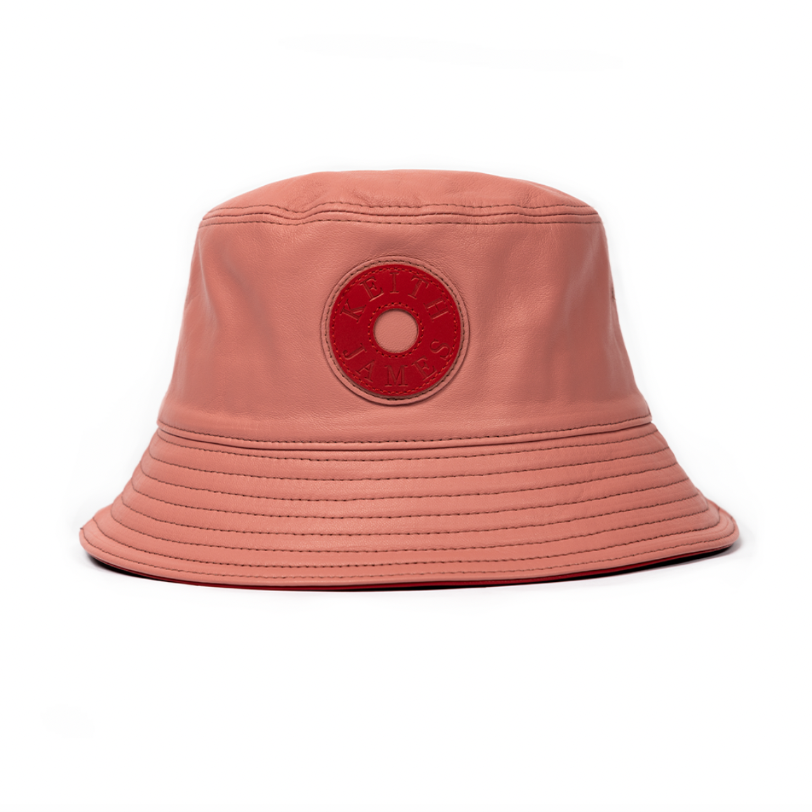 A plush pink leather bucket hat with a stamped leather logo circle on the front.