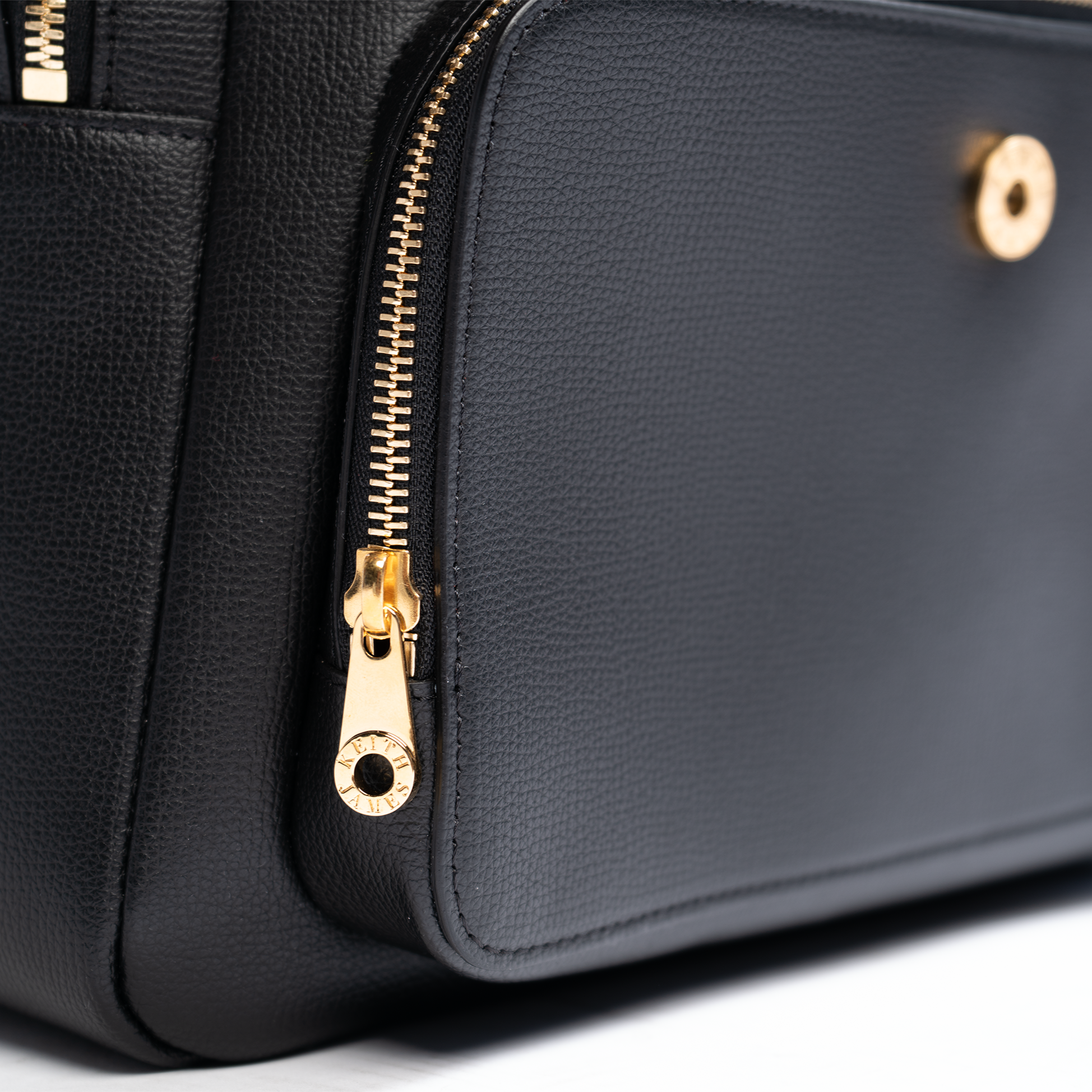 A jet black leather backpack with gold-tone hardware, featuring multiple compartments and a front zipper pocket.