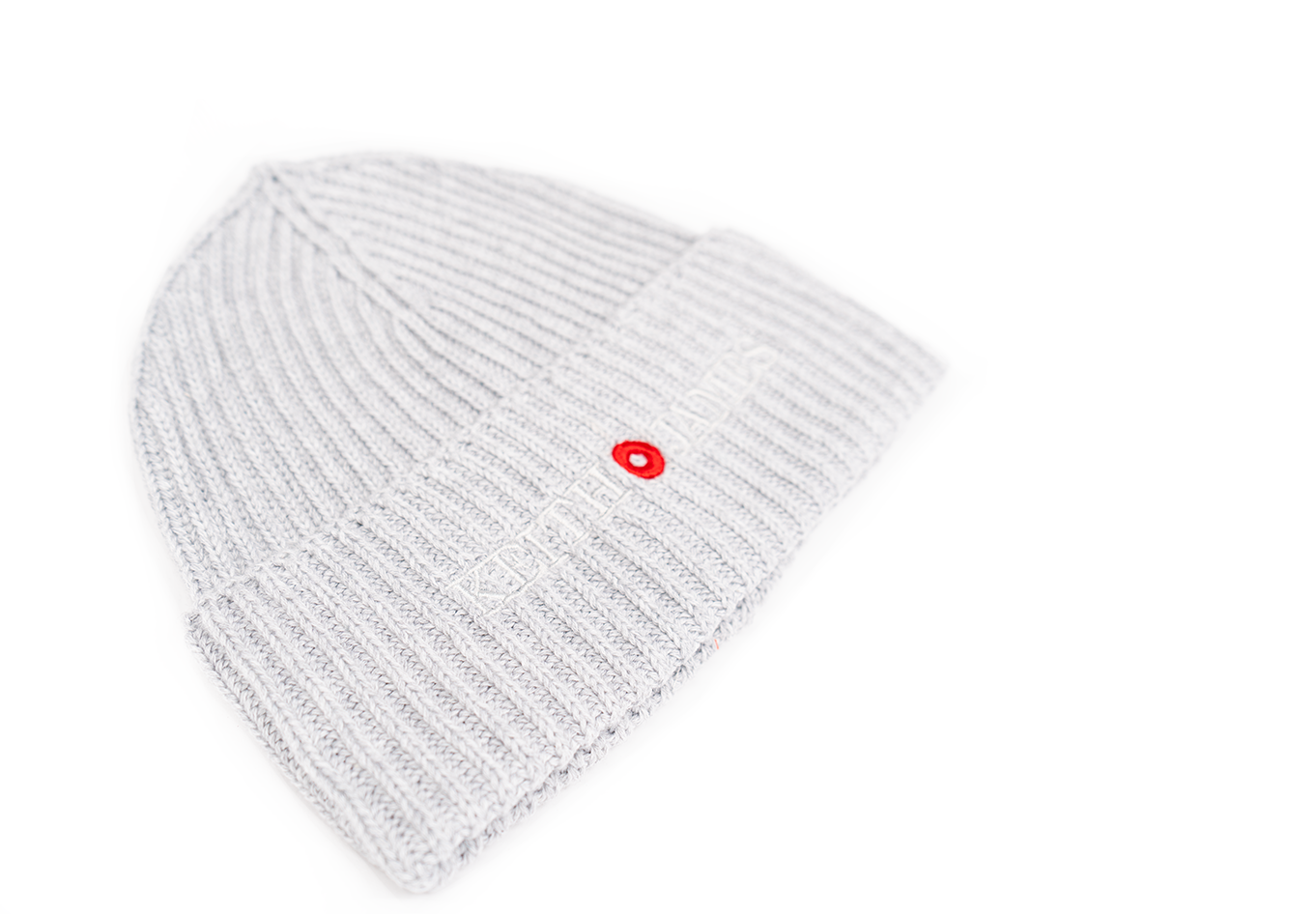 A gray rib-knit beanie with an embroidered logo and a small red circle on the front.