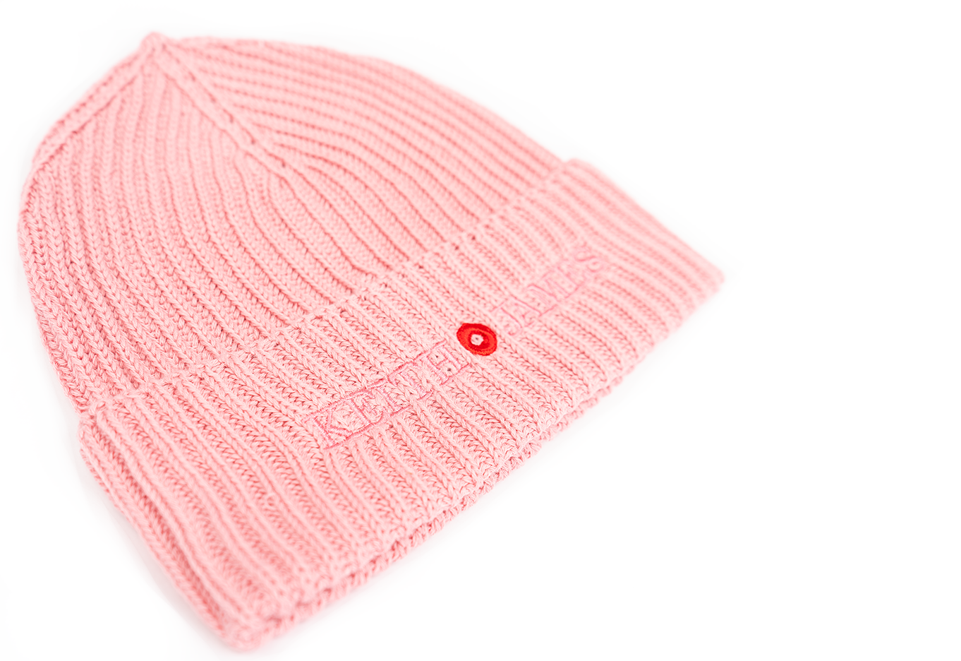 A pink rib-knit beanie with an embroidered logo and a small red button detail on the front.
