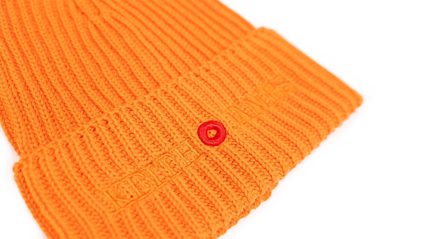 A tiger orange rib-knit beanie with an embroidered logo on the front.