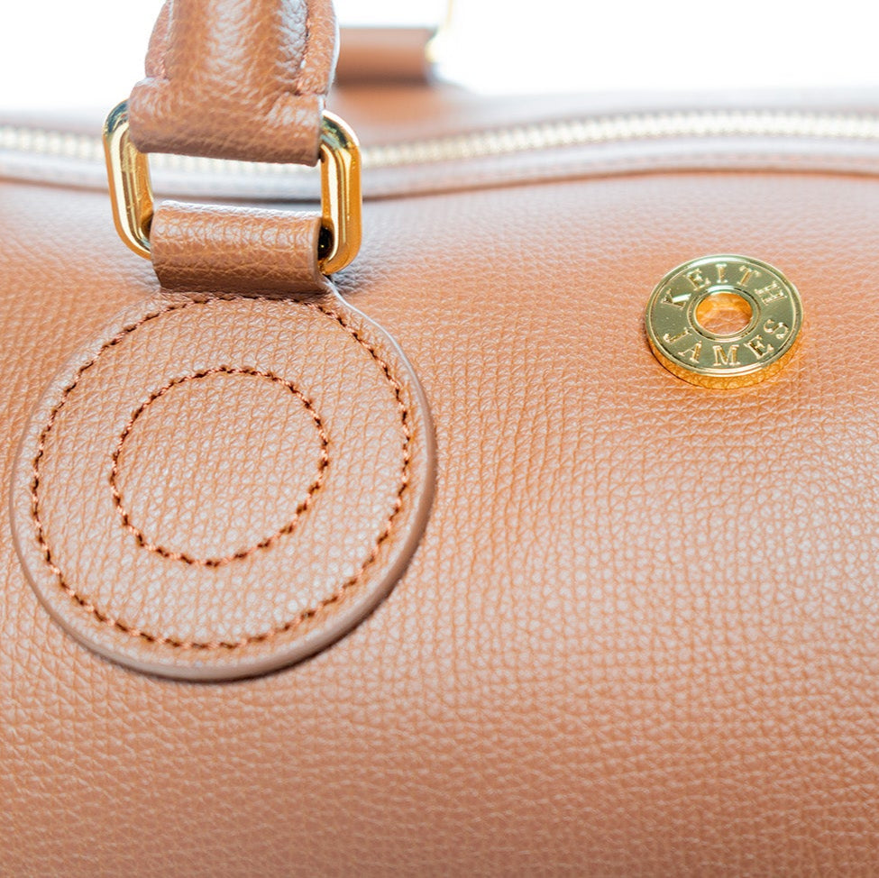 A cocoa brown handbag with a structured shape and gold-tone hardware.