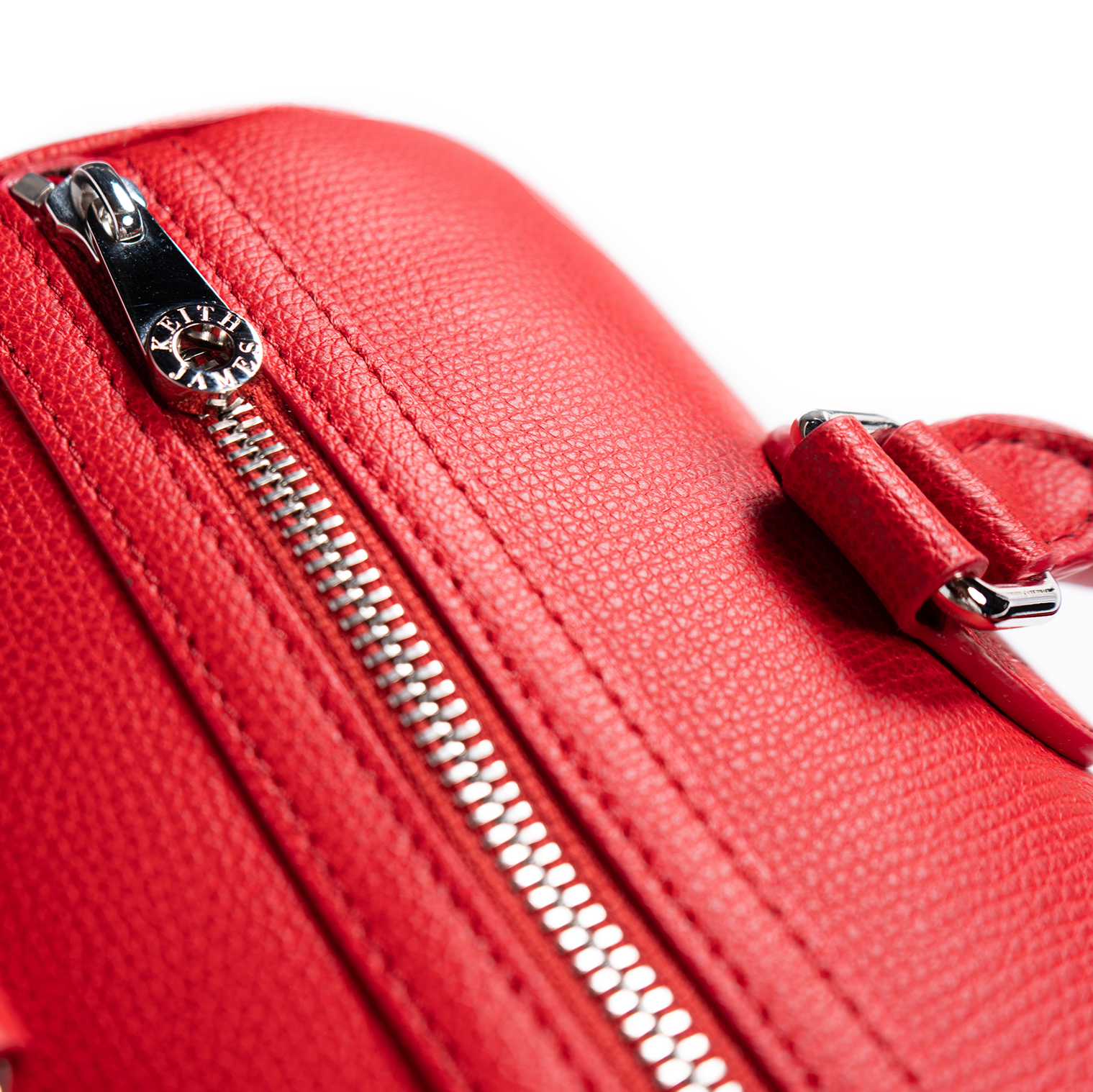 A rose red handbag with a structured design, featuring two handles and a front zipper closure.