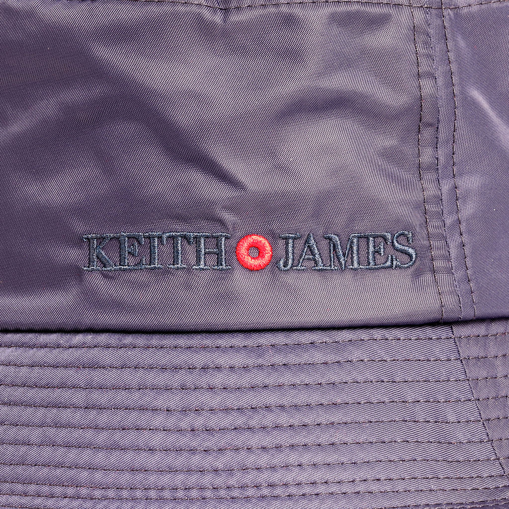 A navy blue bucket hat with a red detail around the base and the brand name 'Keith James' visible on the front.