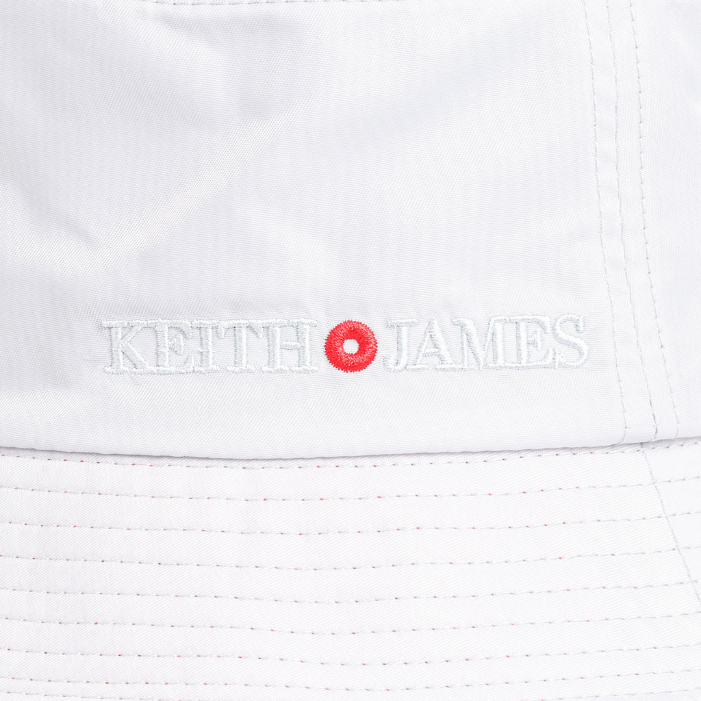 A silver blue bucket hat with a red inner brim, featuring a brand logo on the front.