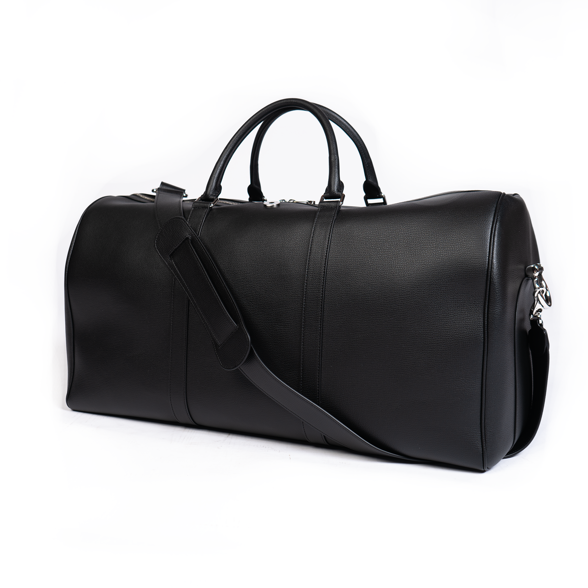 A jet black duffel bag with a detachable strap and gold-tone hardware on a white background.