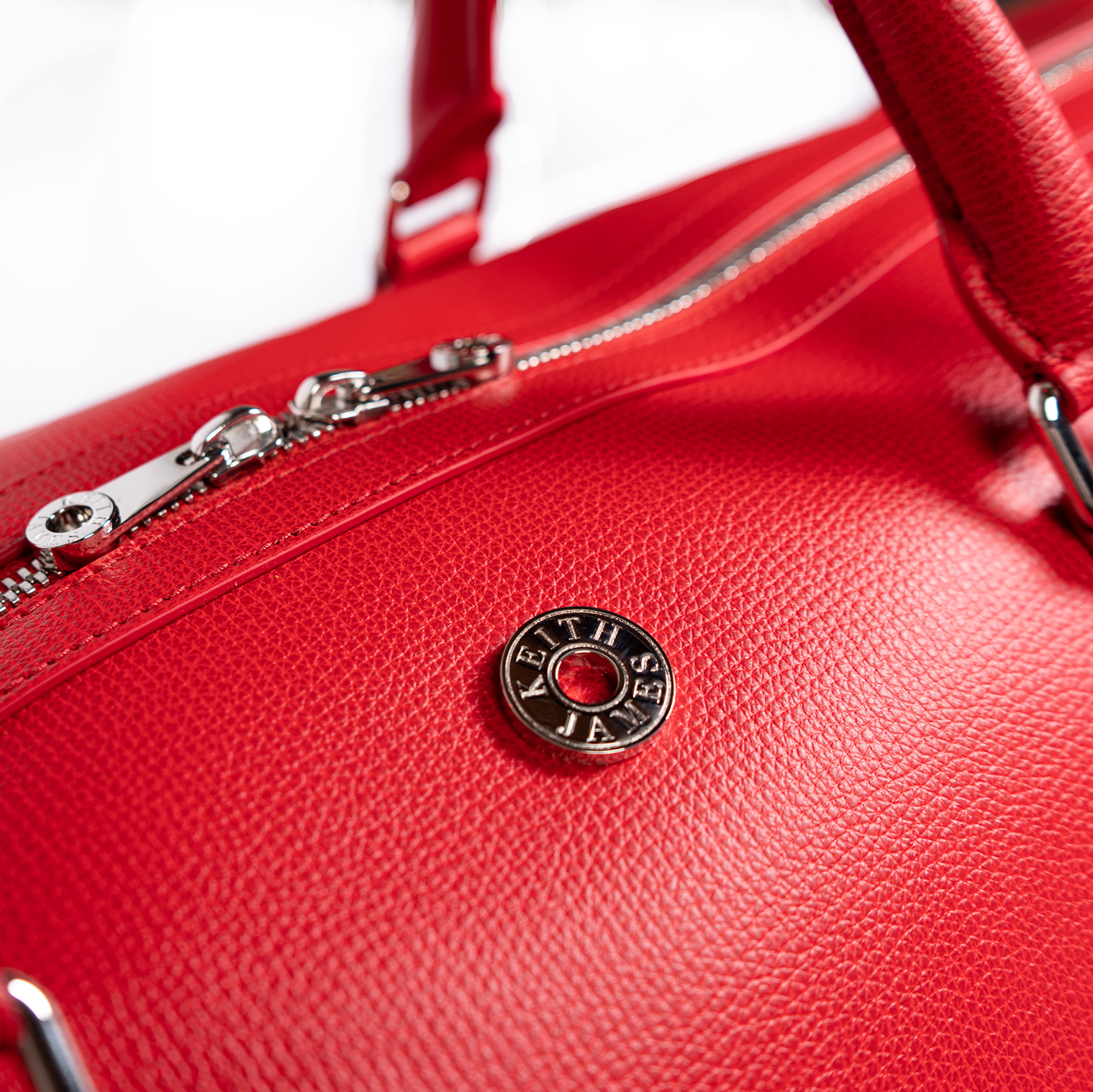 A rose red duffel bag with a detachable strap and a zipper closure.