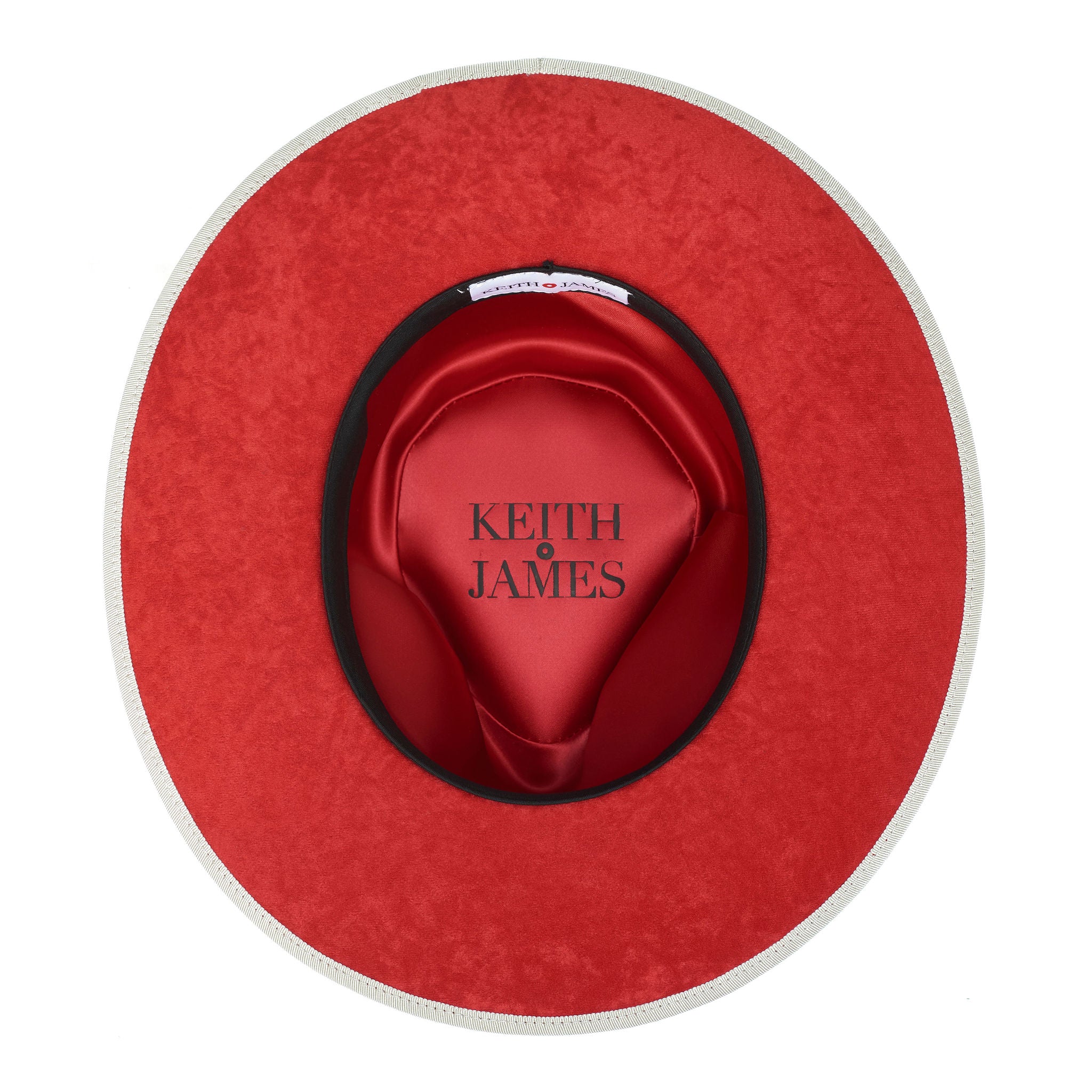 A sandy beige hat with a red bottom brim, a classic wide ribbon, and a bow signature logo pin.