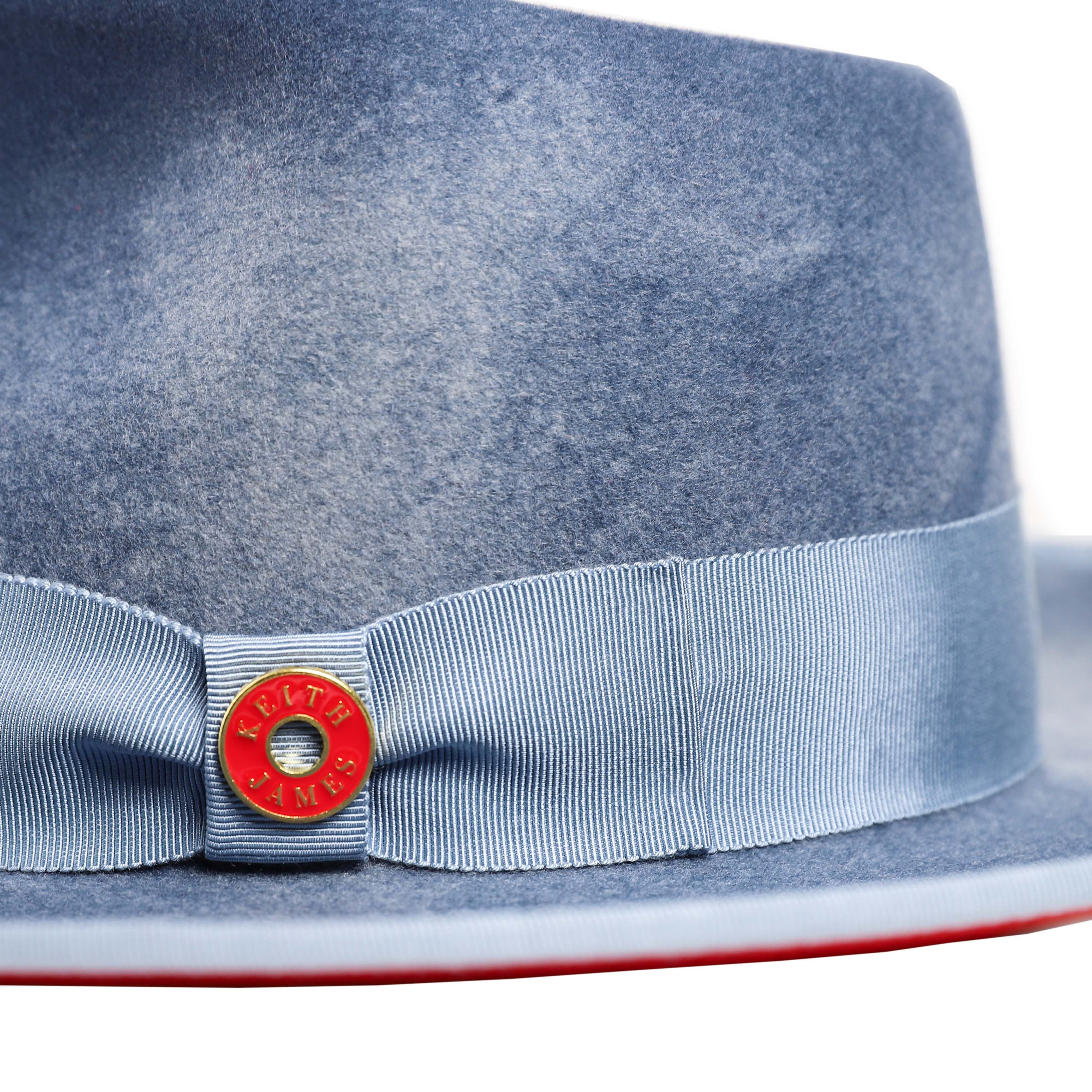 A swirl blue hat with a wide brim and a red bottom, featuring a classic ribbon and bow with a pin, made in the USA.