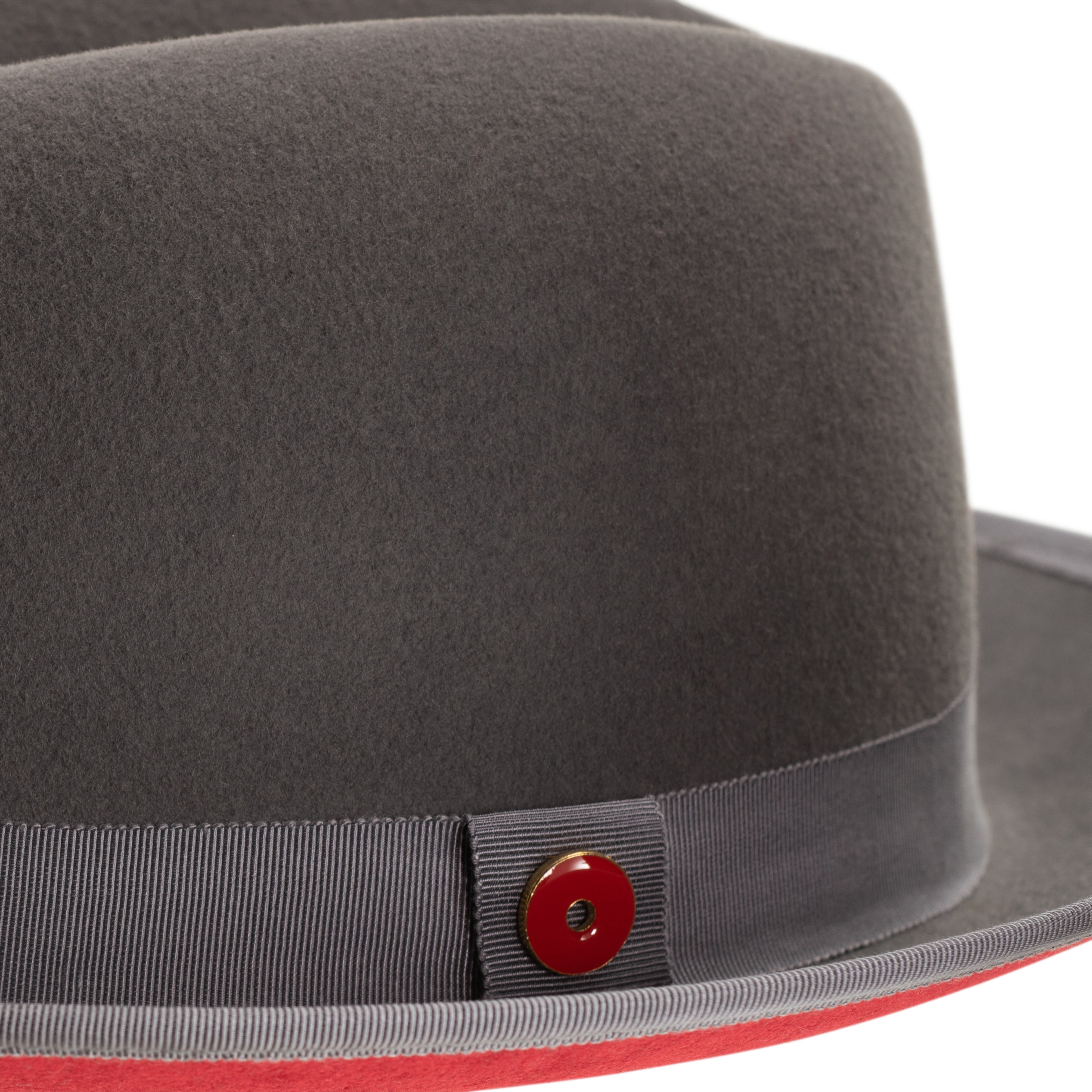 A classic center-creased fedora with a 2.5 inch curved brim featuring a bound edge, signature logo pin, red bottom brim, and a gray ribbon trim.