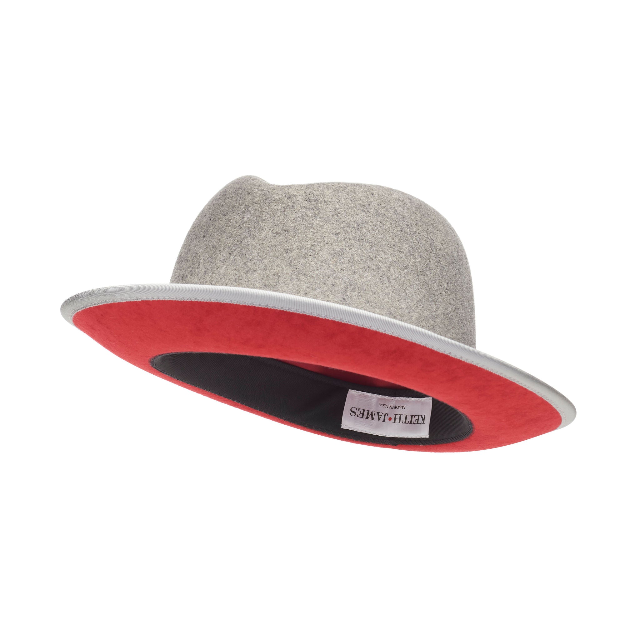A gray fedora hat with a red bottom brim and a signature logo pin.