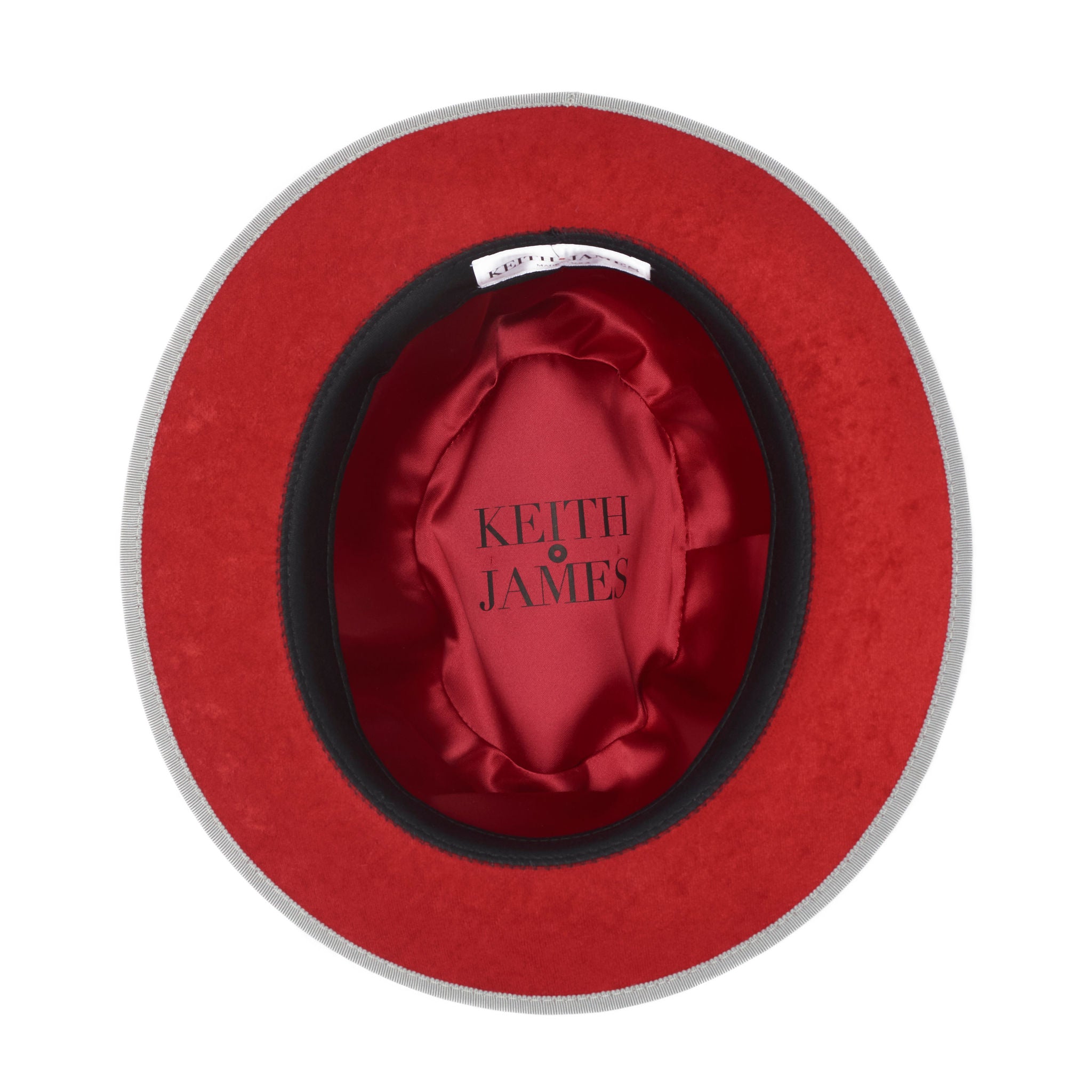 A gray fedora hat with a red bottom brim and a signature logo pin.