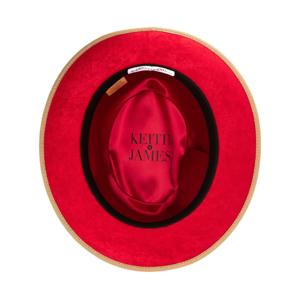 A golden honey straw fedora hat with a red bottom brim and a signature logo pin.