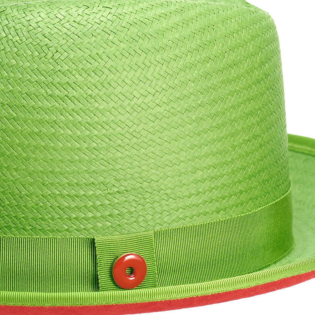 A lime green straw fedora with a red bottom brim and a ribbon trim around the base.
