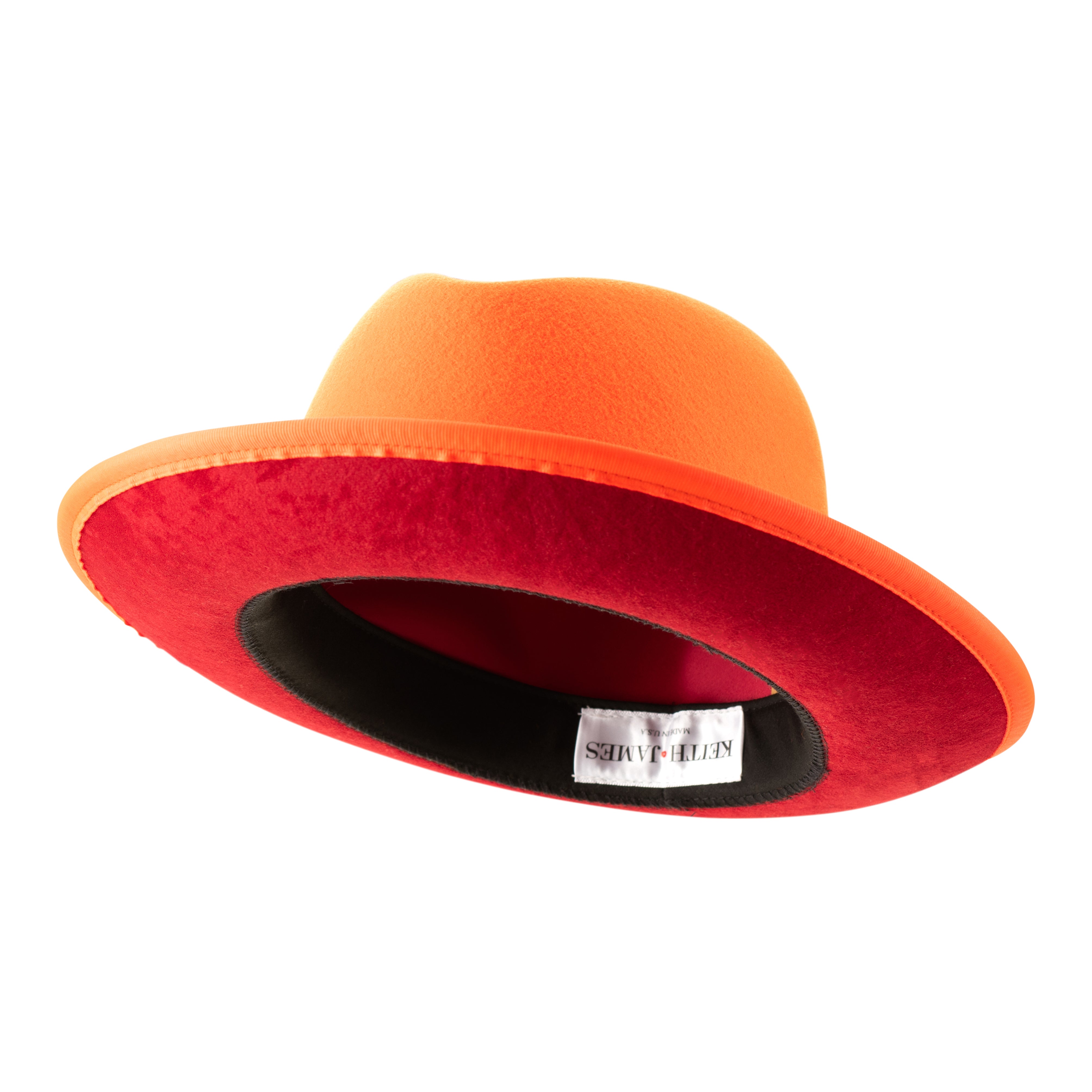 A tiger orange classic center-creased fedora with a 2.5 inch curved brim and a red bottom brim.