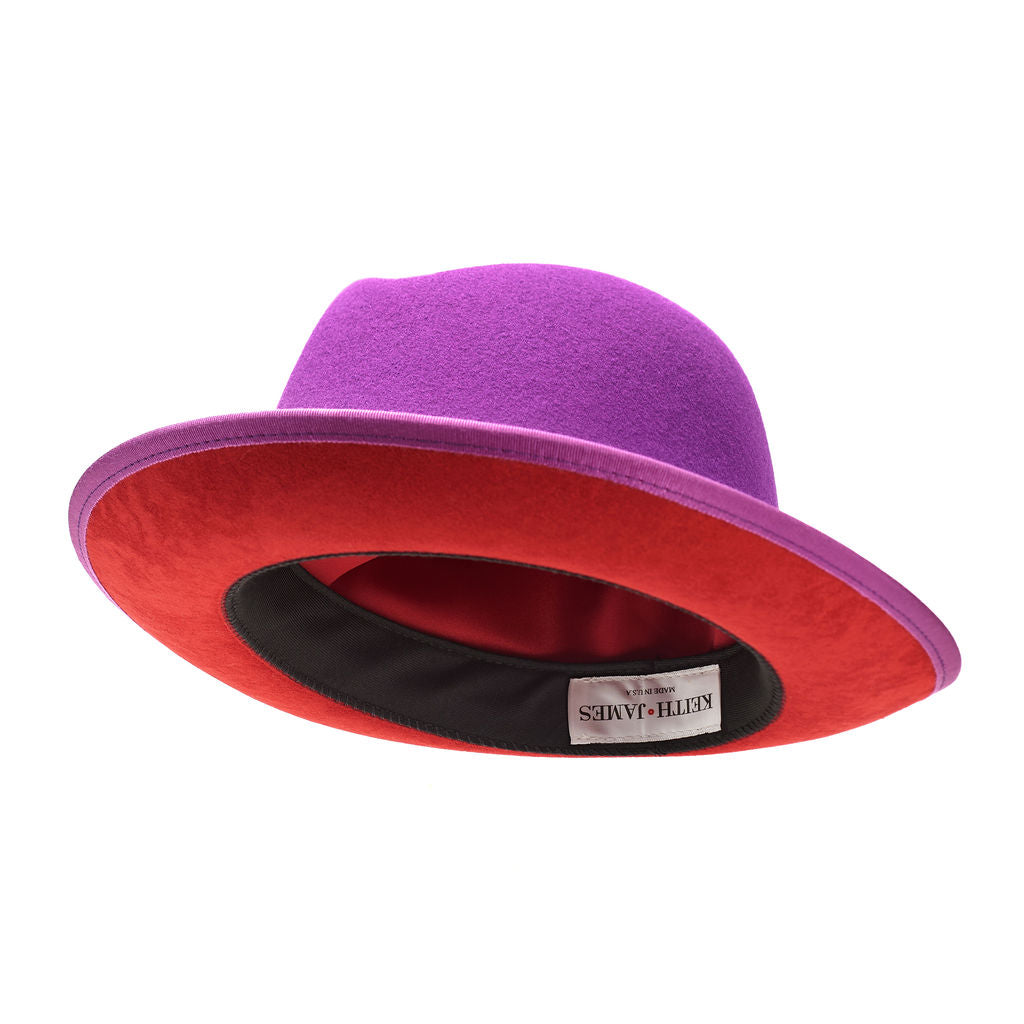 A violet purple classic center-creased fedora with a 2.5 inch curved brim, signature logo pin, and red bottom brim.