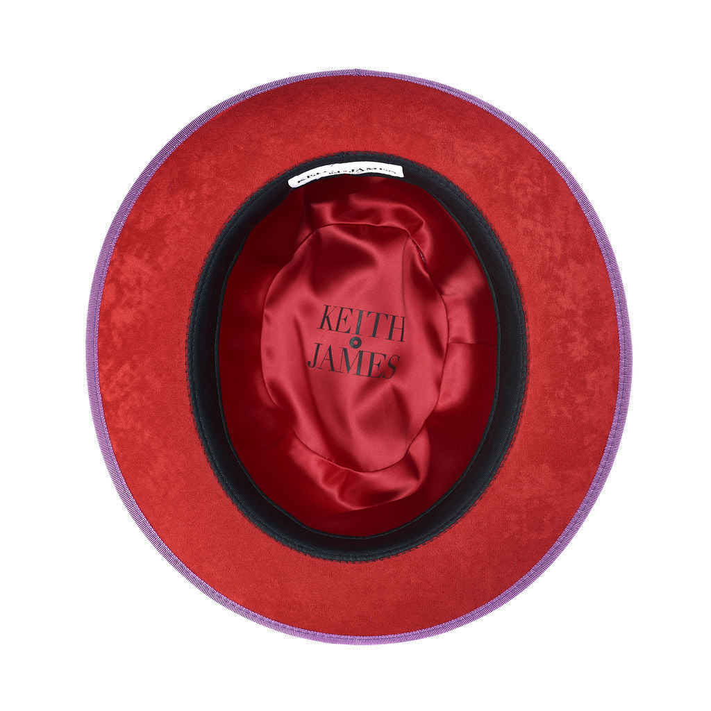 A violet purple classic center-creased fedora with a 2.5 inch curved brim, signature logo pin, and red bottom brim.