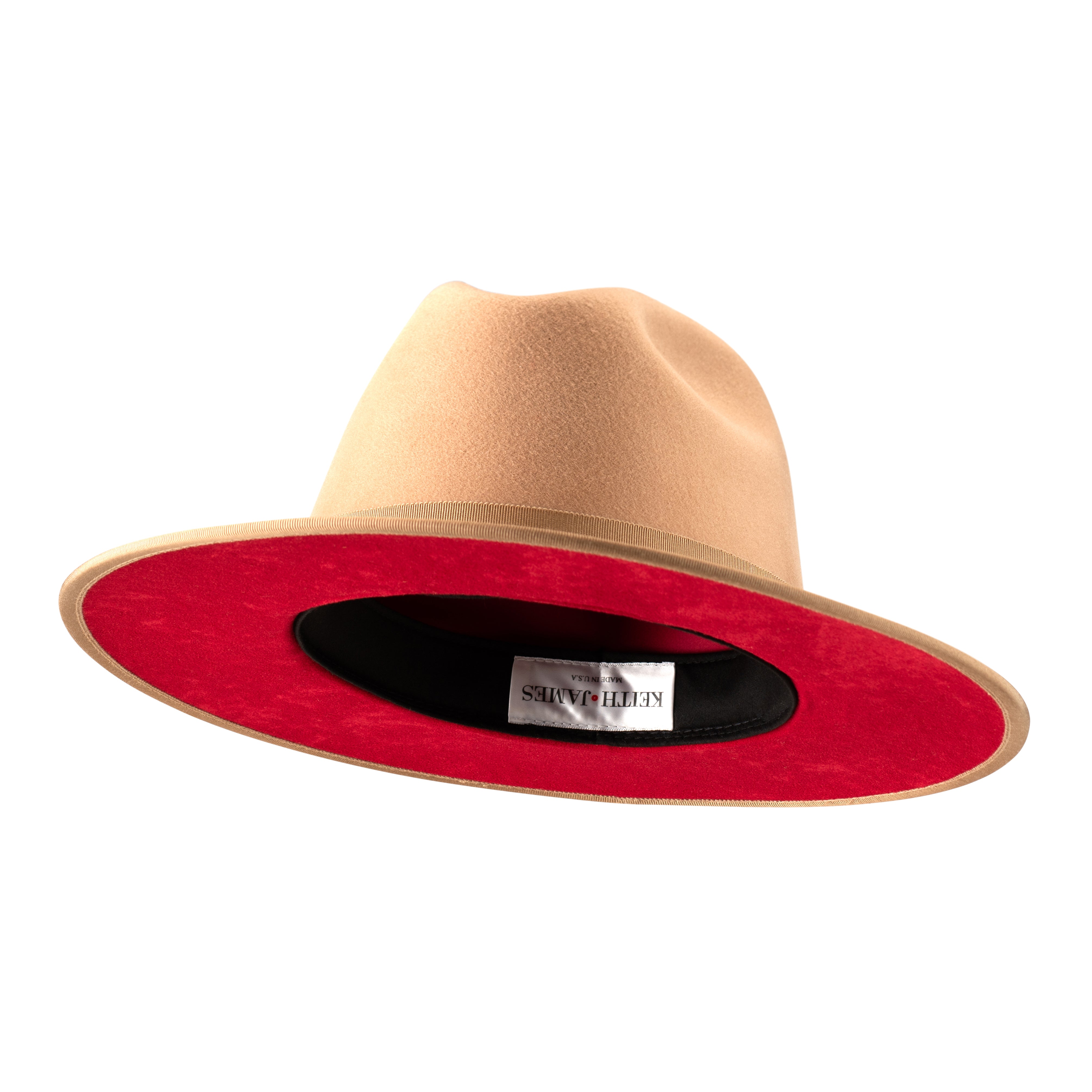 A golden honey fedora hat with a pinched crown, flat brim, and bound edge. It includes a classic ribbon trim, a signature logo pin, and a red bottom brim.